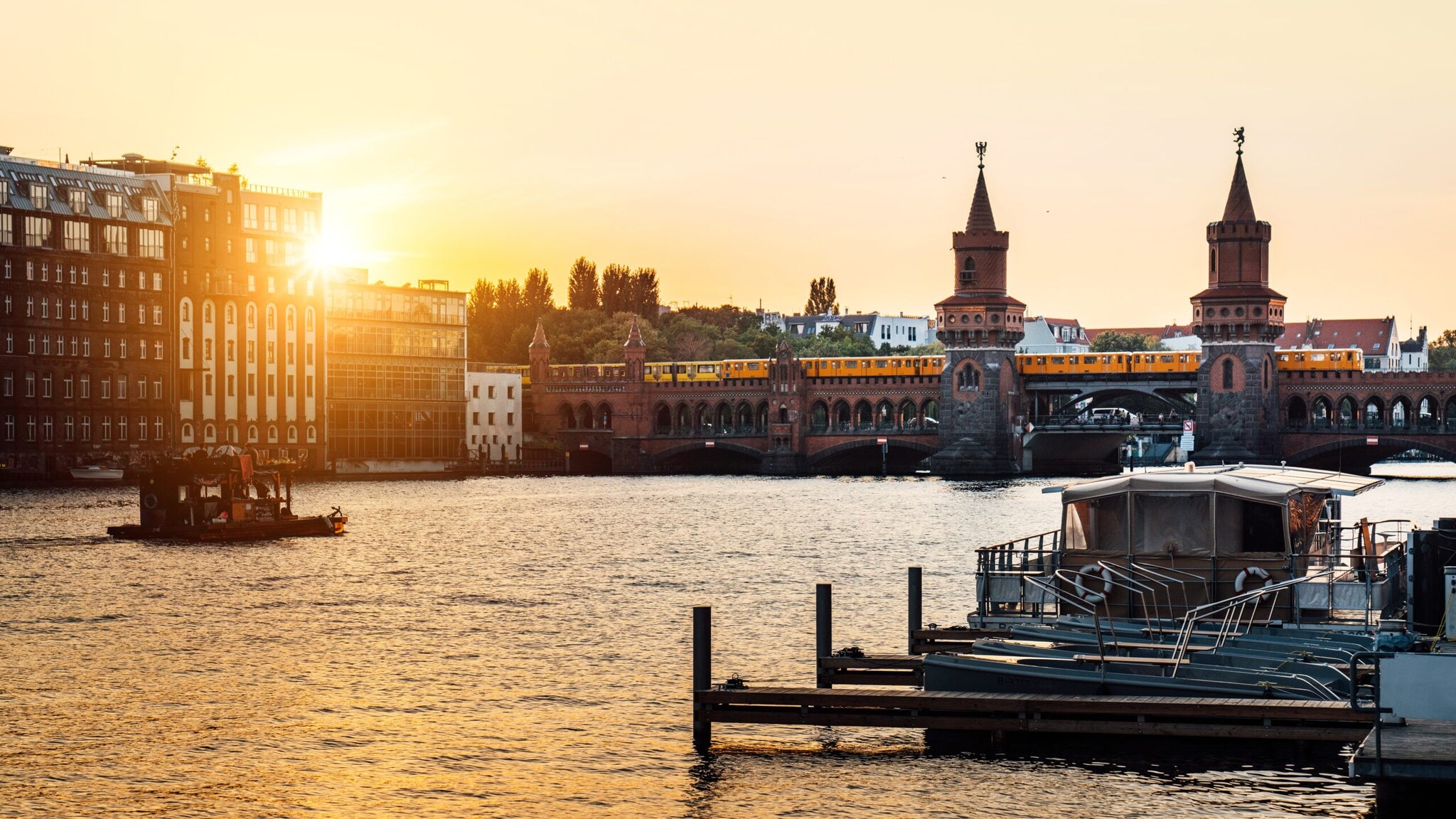 Sonnenuntergang über der Oberbaumbrücke in Berlin mit vorbeifahrender U-Bahn und Booten auf der Spree. Sonnenuntergang über der Oberbaumbrücke in Berlin mit vorbeifahrender U-Bahn und Booten auf der Spree.