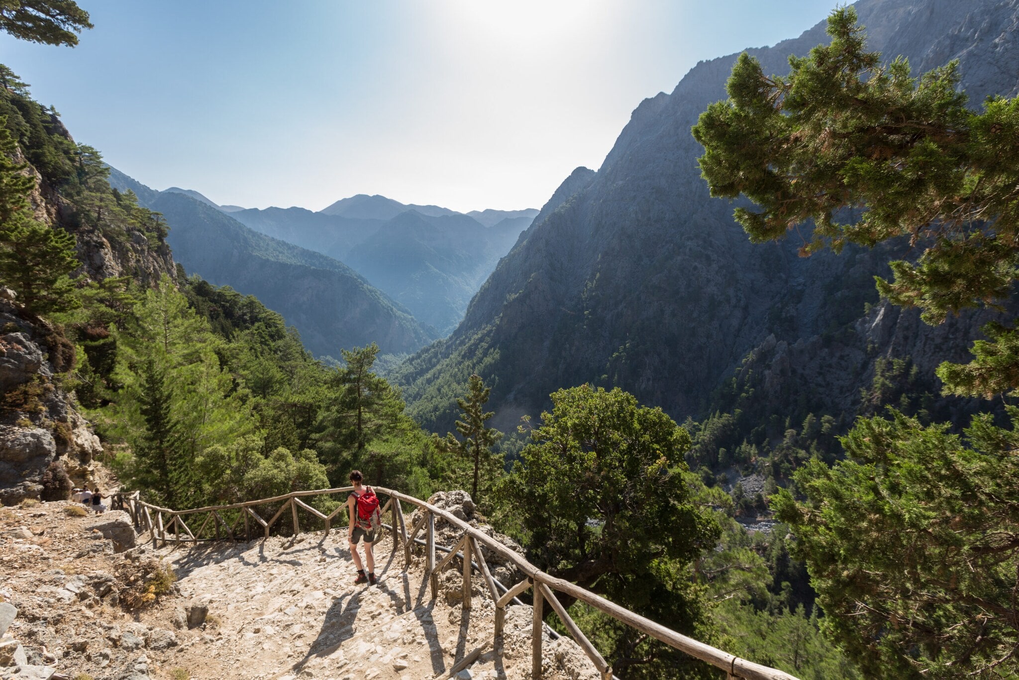 Eine Person beim Wandern in der Samaria-Schlucht auf Kreta, im Hintergrund Vegetation und Berggipfel. Eine Person beim Wandern in der Samaria-Schlucht auf Kreta, im Hintergrund Vegetation und Berggipfel.