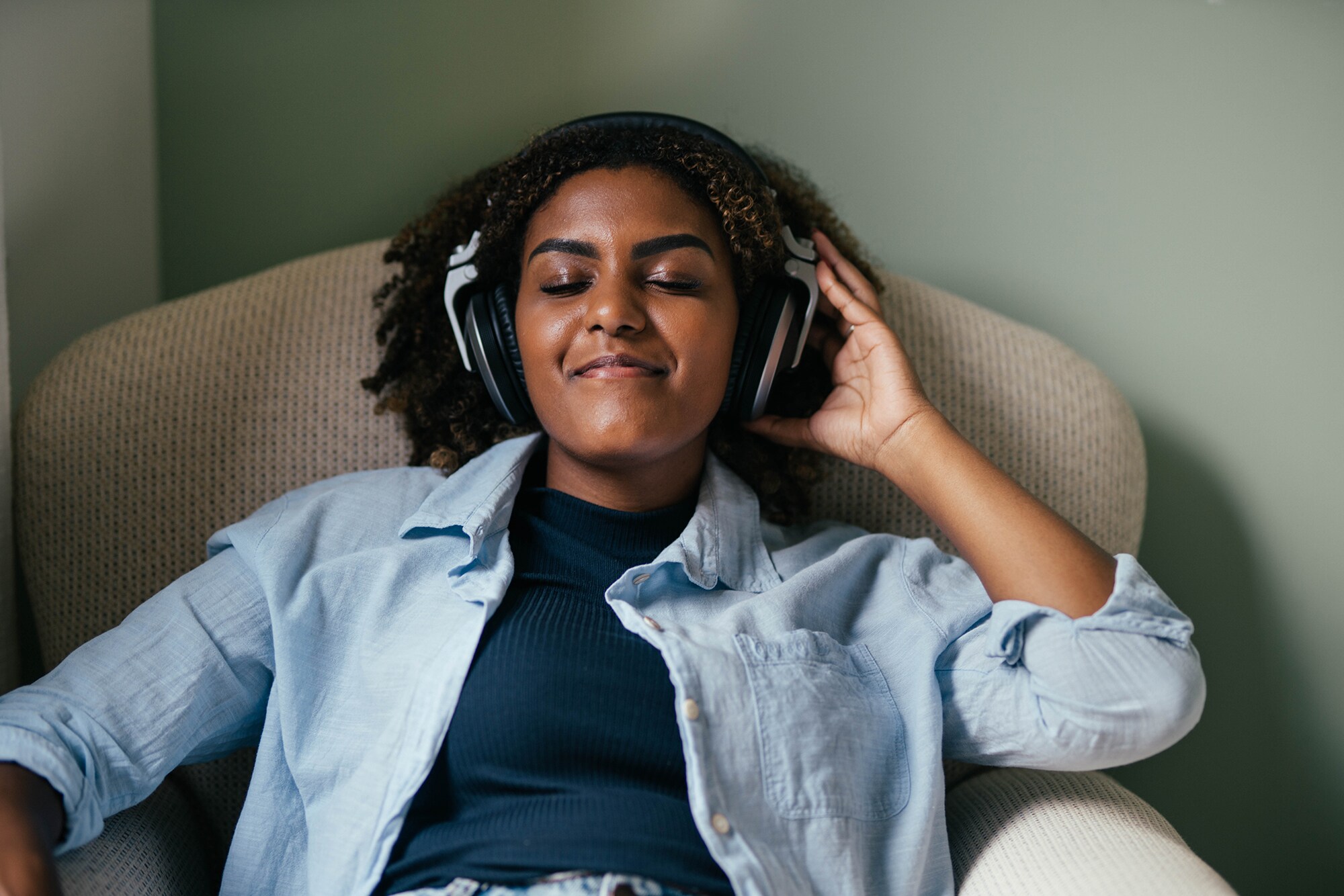 Eine Frau hört Musik mit geschlossenen Augen.