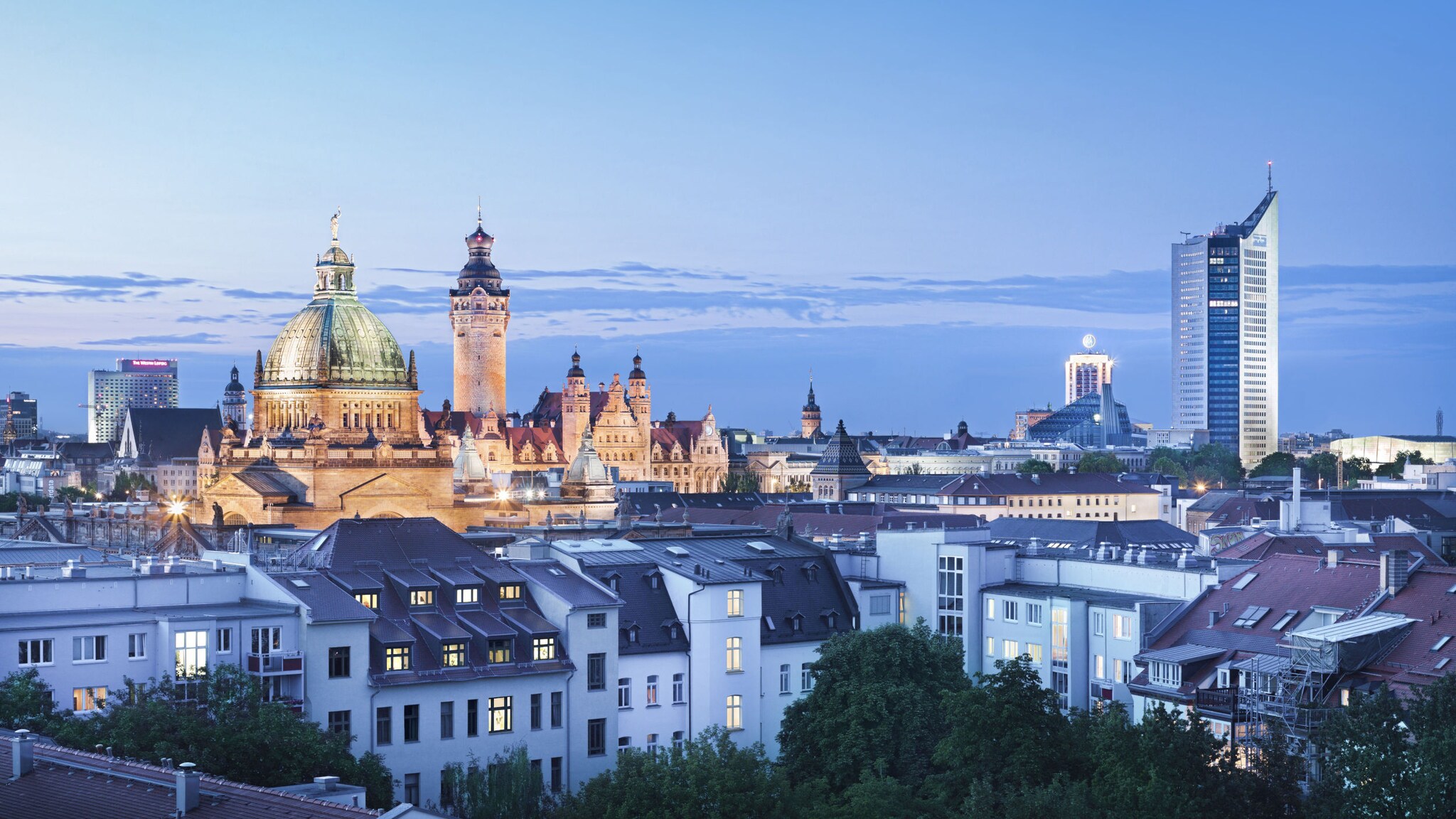 Skyline von Leipzig bei Abenddämmerung mit markanter Kuppel der Nikolaikirche und dem City-Hochhaus im Hintergrund Skyline von Leipzig bei Abenddämmerung mit markanter Kuppel der Nikolaikirche und dem City-Hochhaus im Hintergrund