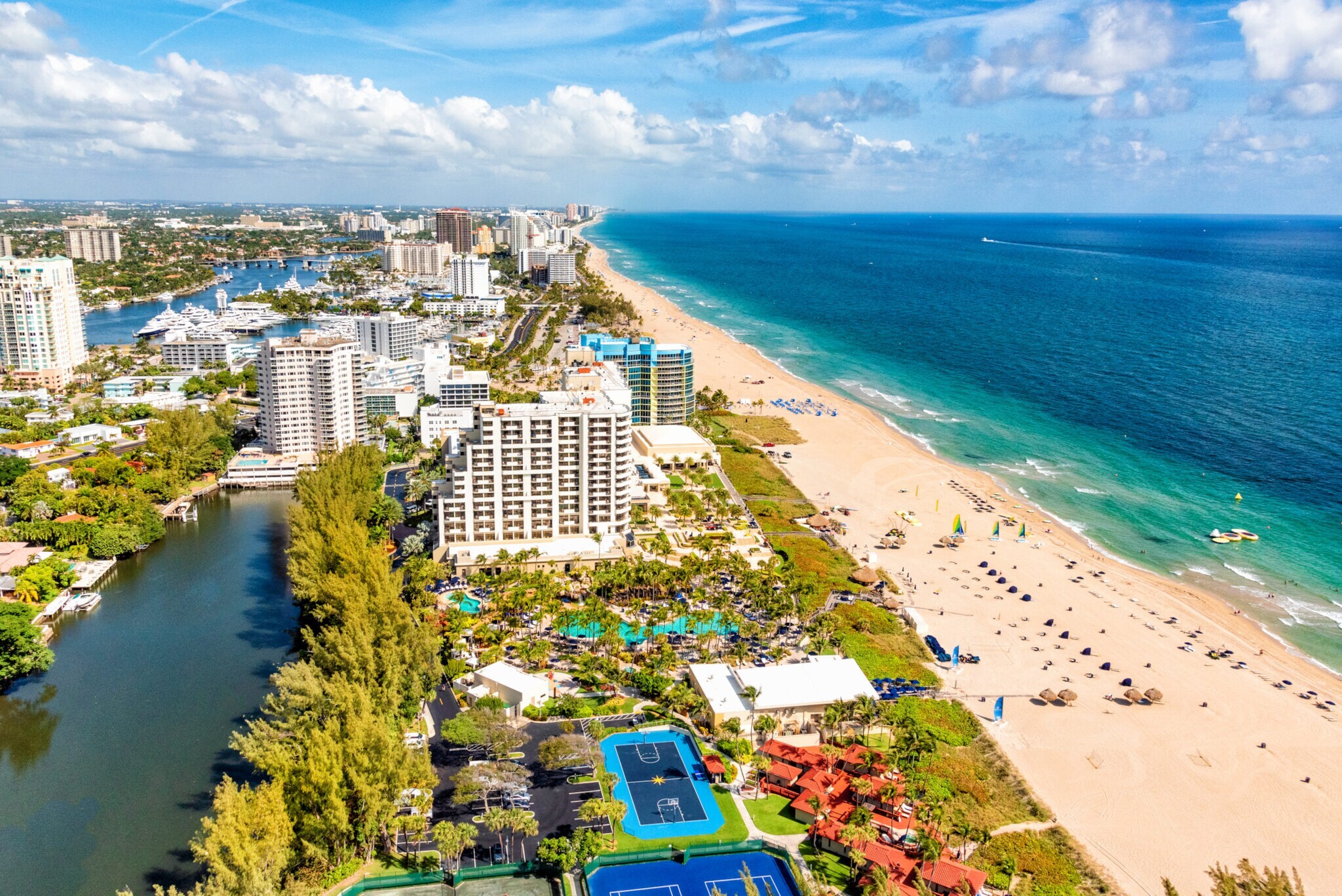 Luftaufnahme von Fort Lauderdale mit Hochhäusern und einem langen Strand am türkisblauen Meer. Luftaufnahme von Fort Lauderdale mit Hochhäusern und einem langen Strand am türkisblauen Meer.