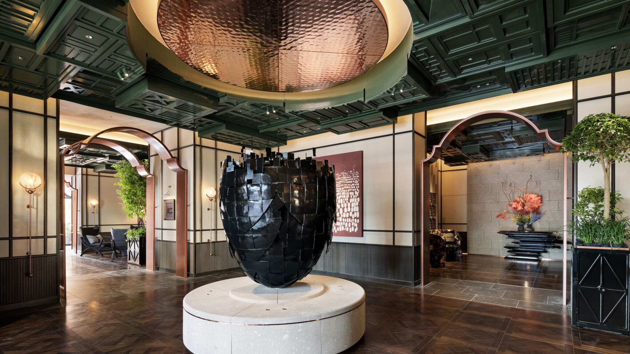 Eingangshalle mit großem, schwarzen, skulpturalen Kunstwerk auf rundem Podest, dunklem Holzparkett und dekorativer Decke Eingangshalle mit großem, schwarzen, skulpturalen Kunstwerk auf rundem Podest, dunklem Holzparkett und dekorativer Decke