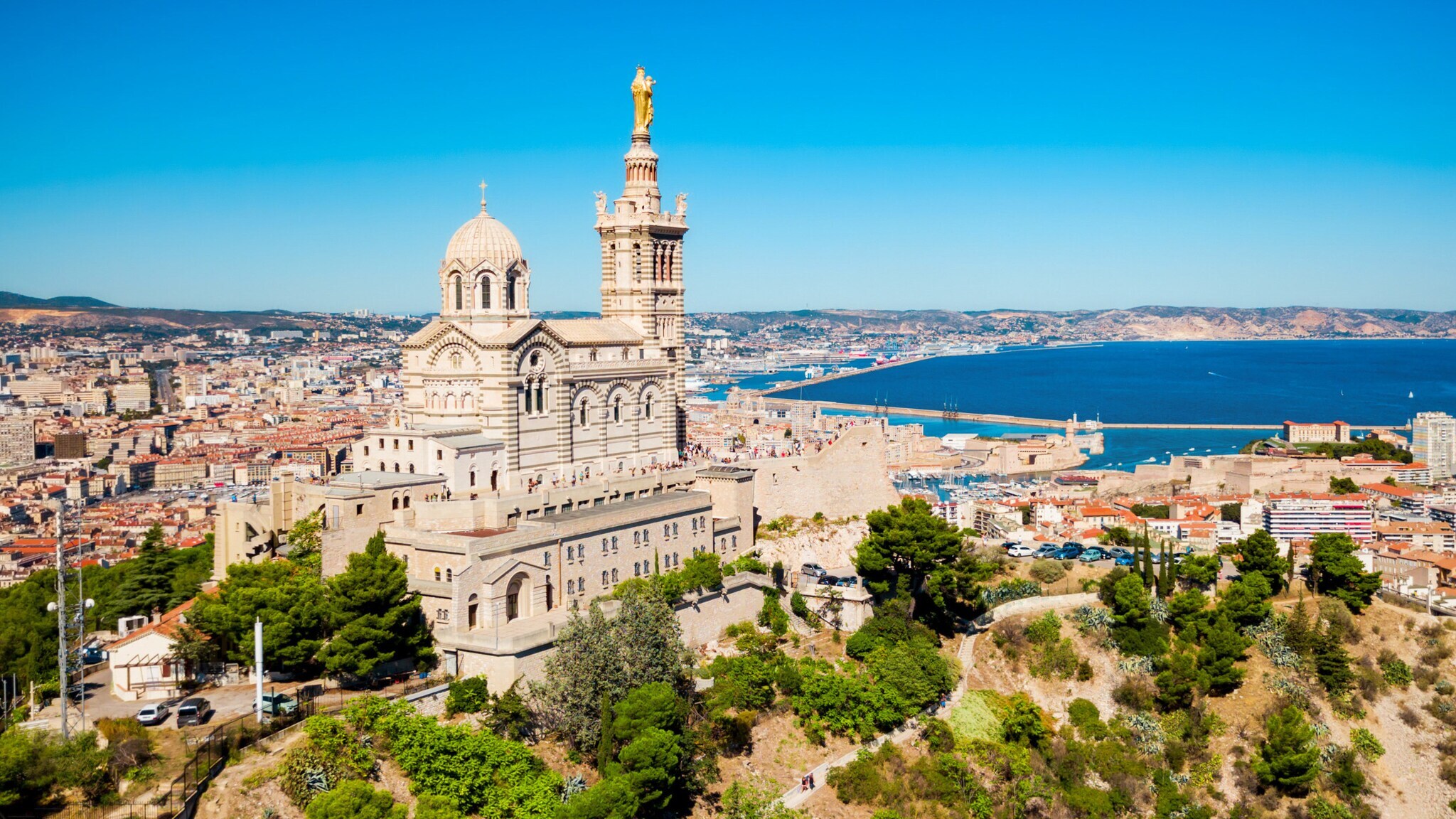 Basilika Notre-Dame de la Garde auf einem Hügel mit Blick auf Marseille und das Mittelmeer bei klarem Himmel
