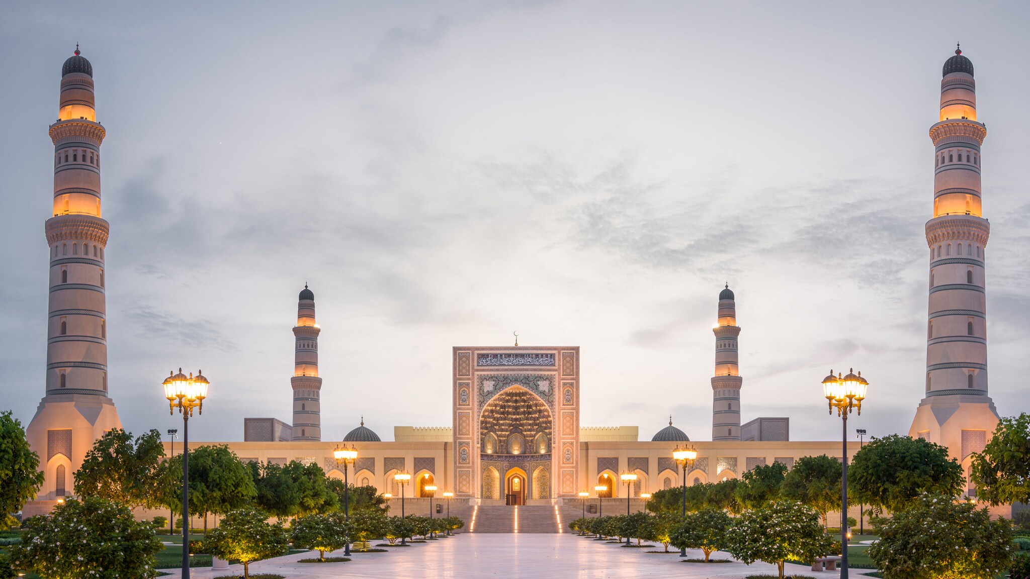Große Moschee mit vier hohen Minaretten und einem verzierten Eingangstor bei Dämmerung