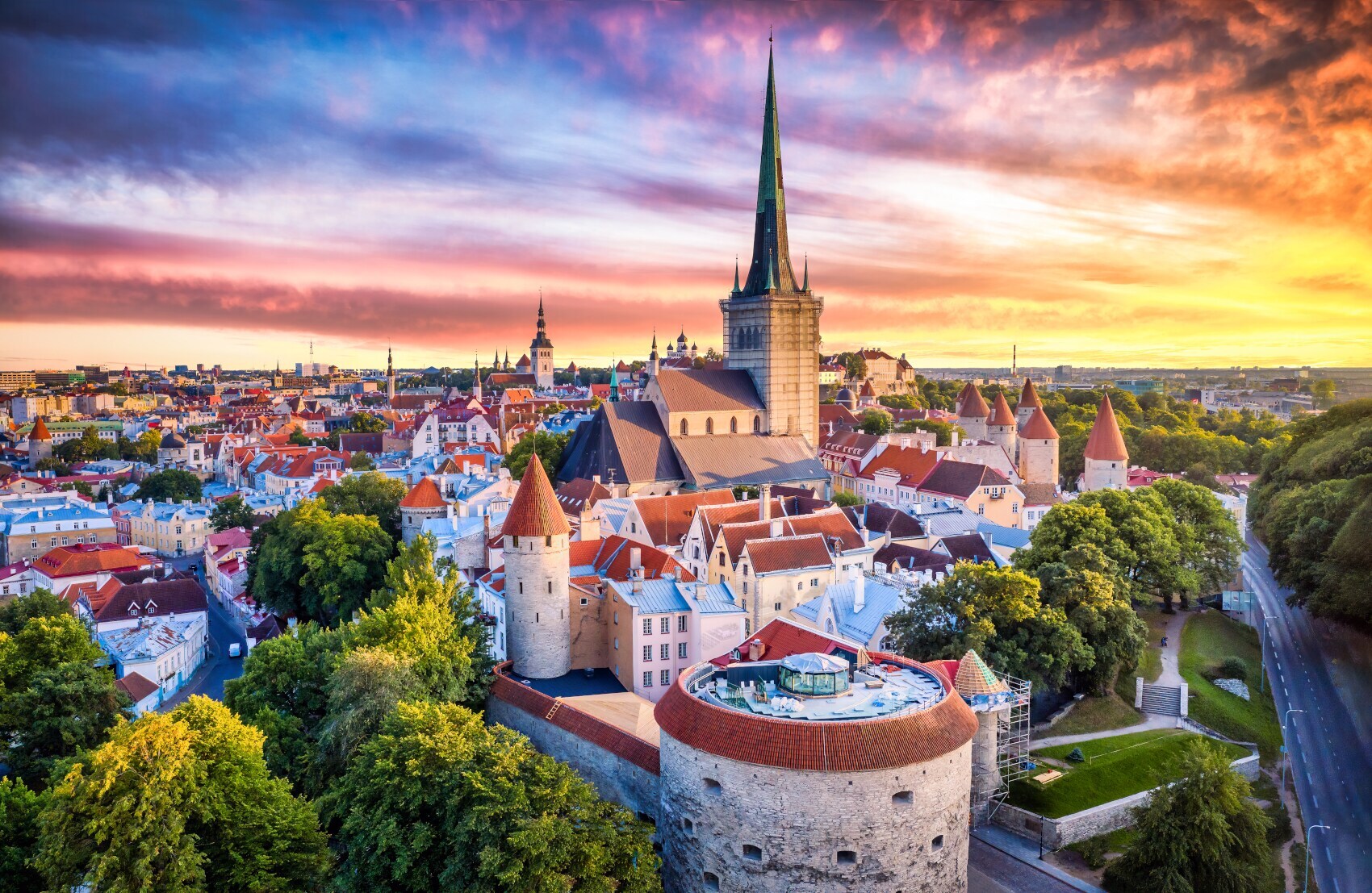 Luftaufnahme der Tallinner Altstadt bei Sonnenuntergang im Sommer, mit dem Turm der „Dicken Margarete“ im Vordergrund.