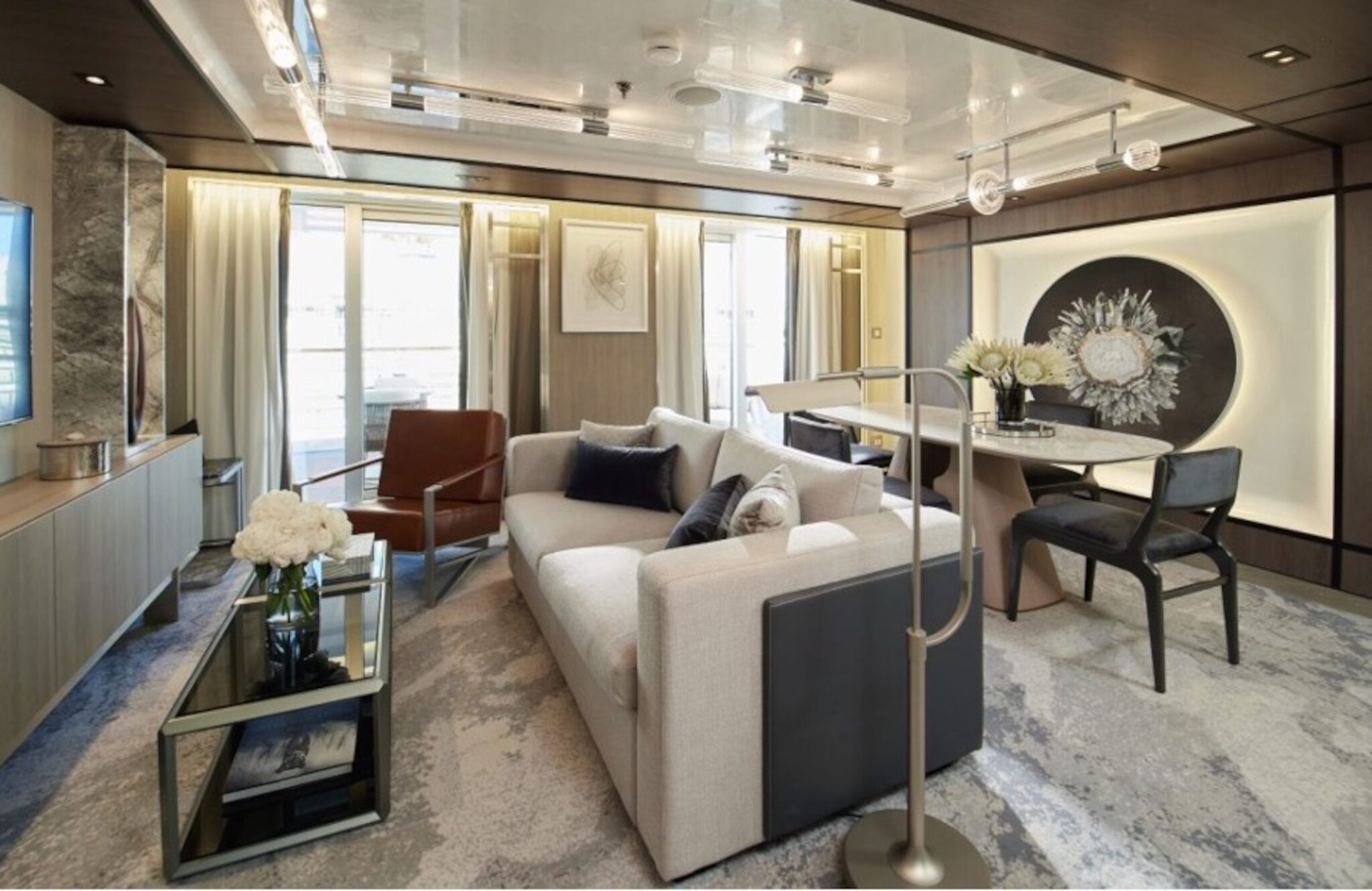 Helles Wohnzimmer einer luxuriösen Suite mit Balkon.