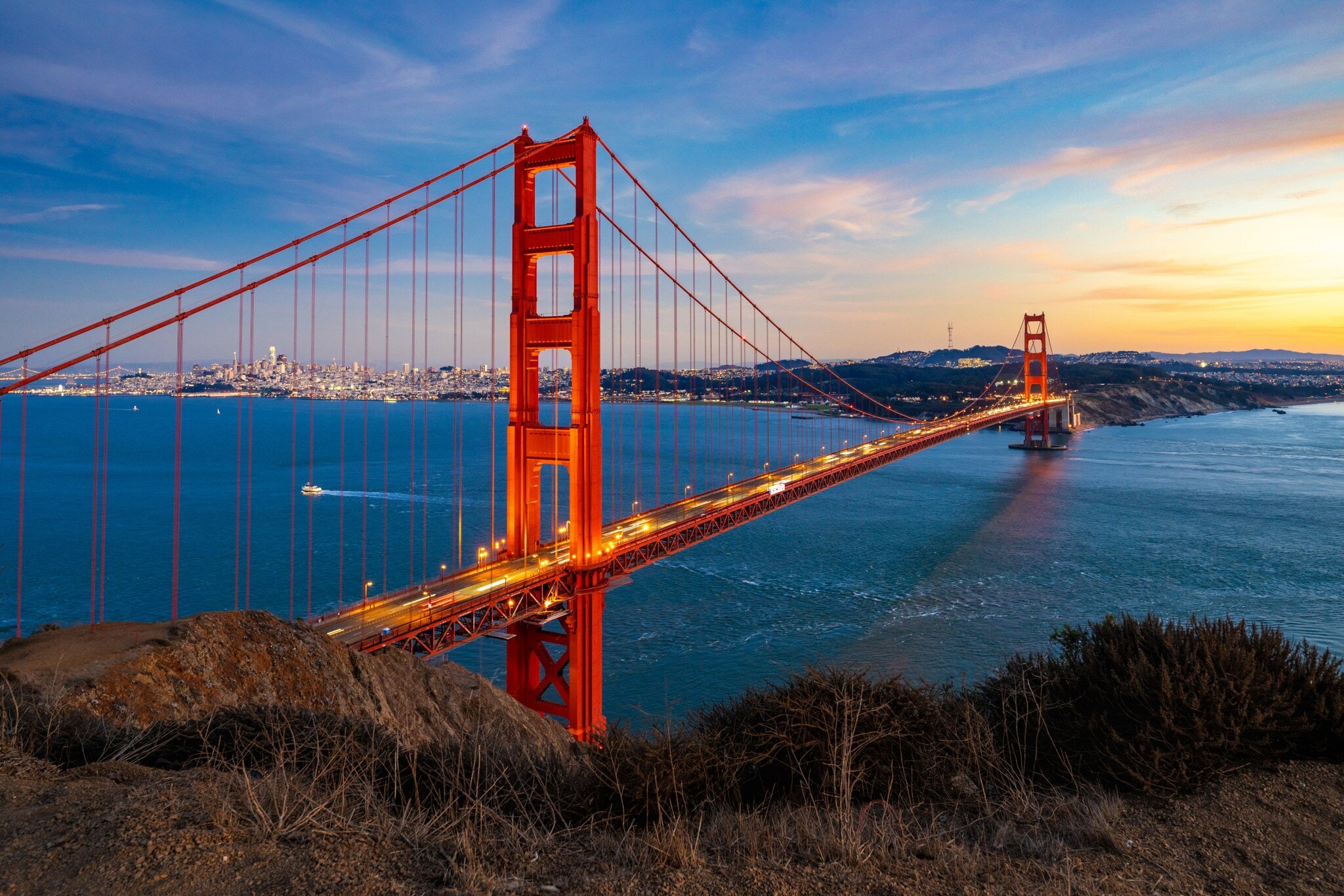 Sonnenuntergang über der Golden Gate Bridge in San Francisco, im Hintergrund die Lichter der Stadt. Sonnenuntergang über der Golden Gate Bridge in San Francisco, im Hintergrund die Lichter der Stadt.