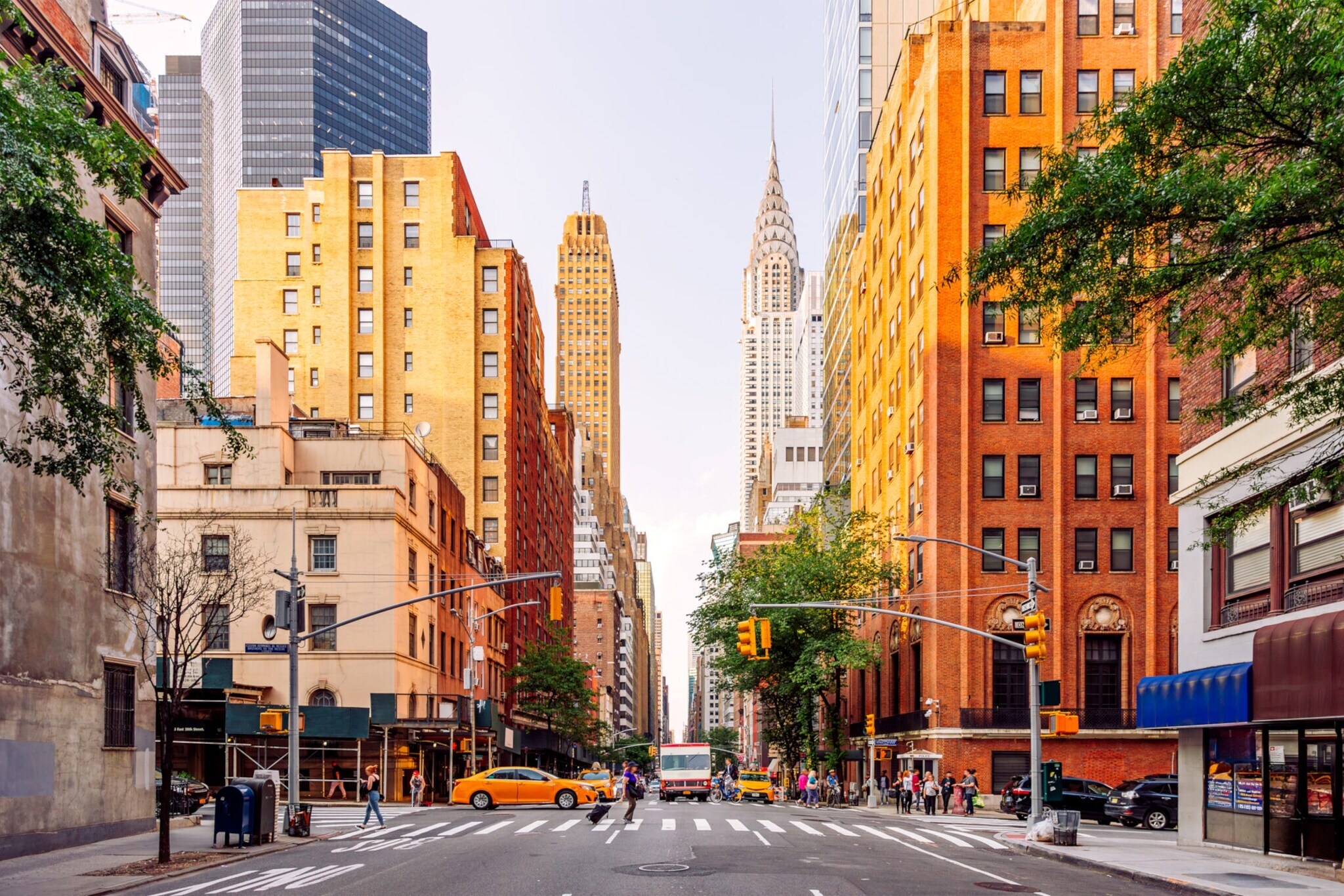 Straße in Midtown Manhattan an einem Sommertag in New York City, das ikonische Chrysler Building im Hintergrund.