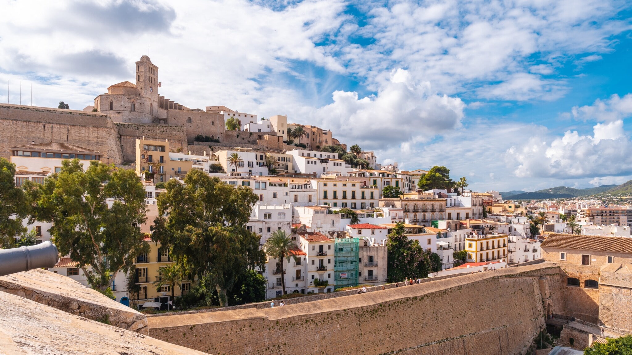 Blick auf die Altstadt von Ibiza mit weißen Häusern und der Kathedrale auf einem Hügel unter bewölktem Himmel Blick auf die Altstadt von Ibiza mit weißen Häusern und der Kathedrale auf einem Hügel unter bewölktem Himmel