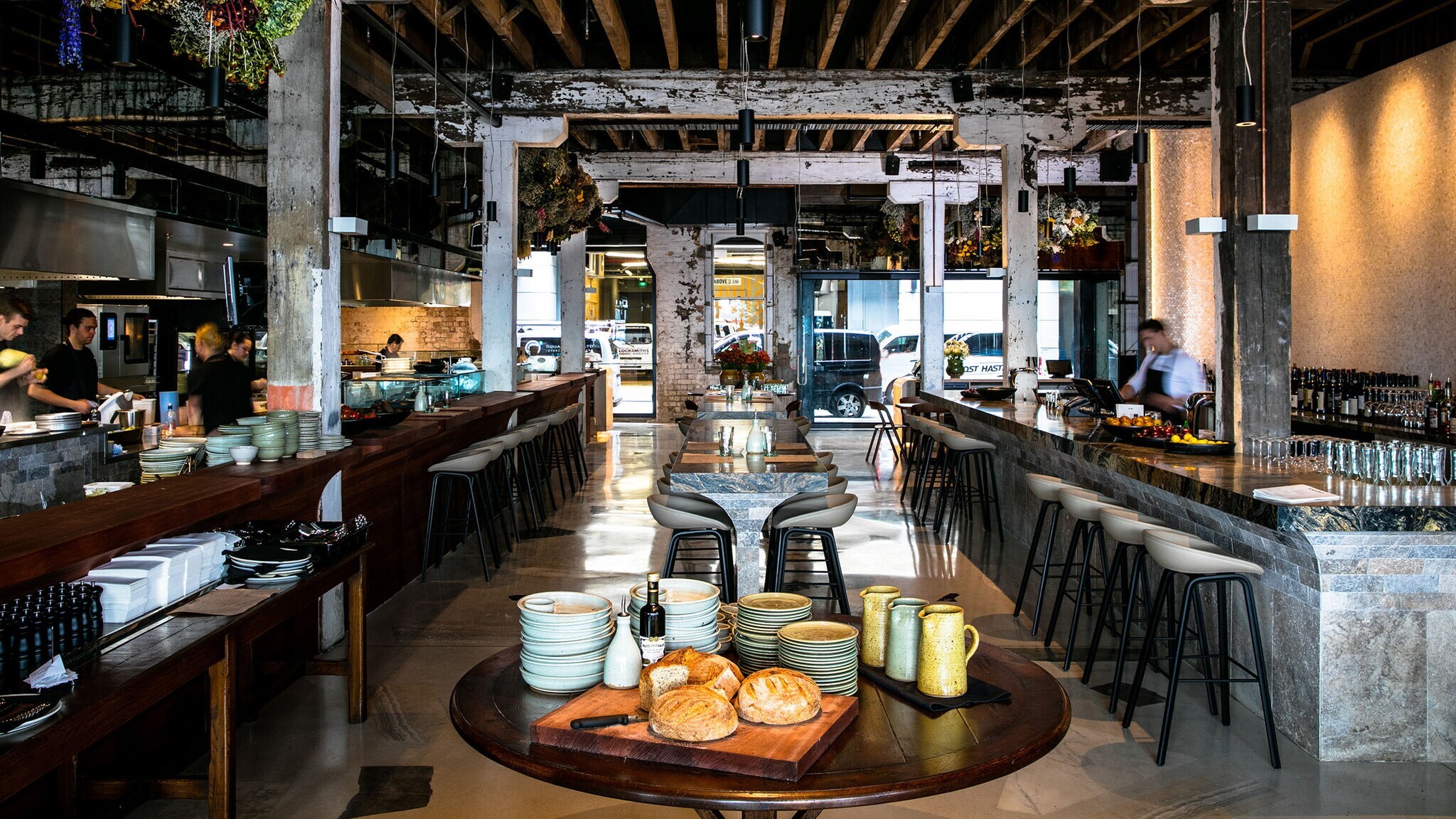 Modernes Restaurant im Industrie-Stil mit offener Küche und Bar.