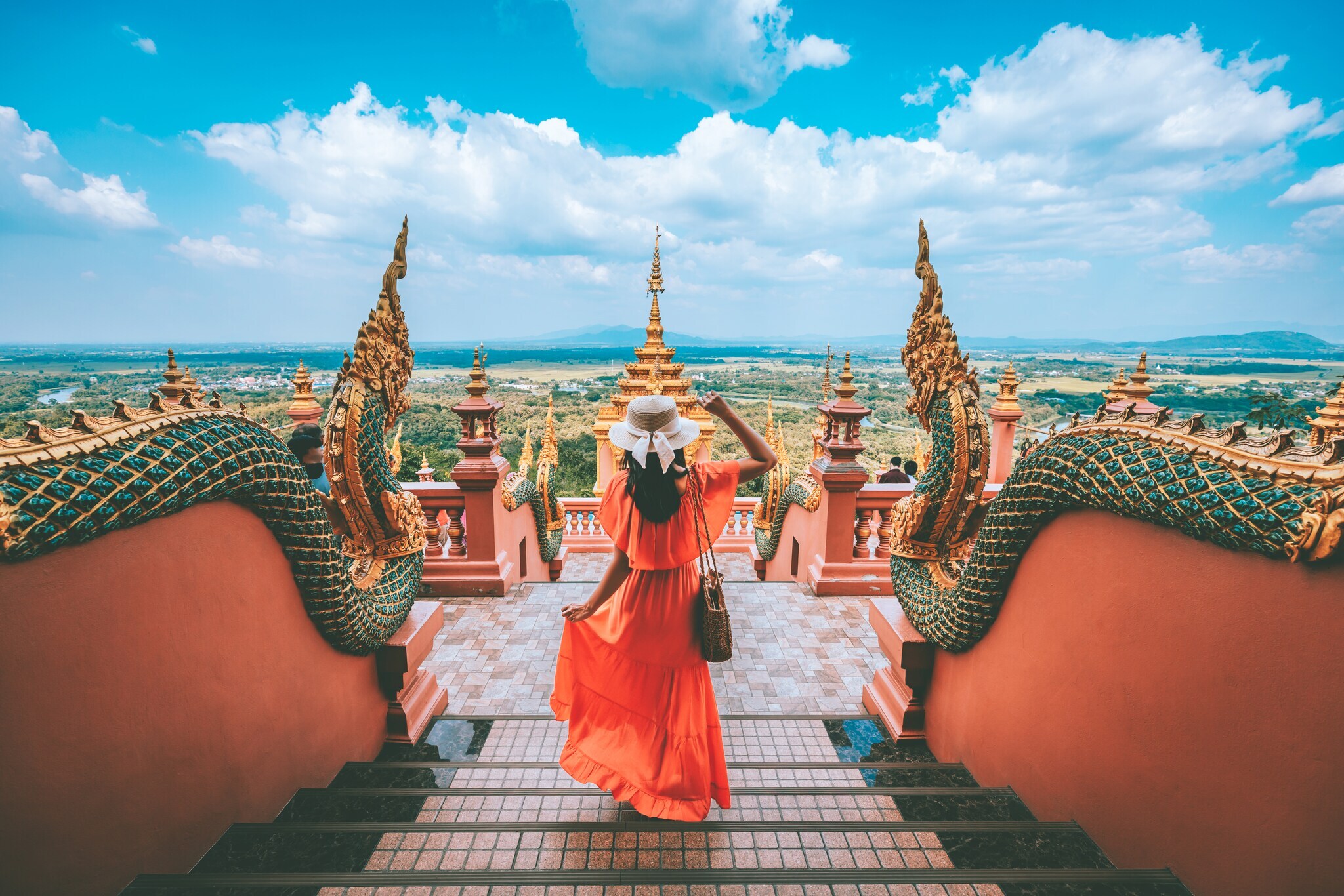 Eine Urlauberin steht in einer Tempelanlage in Thailand