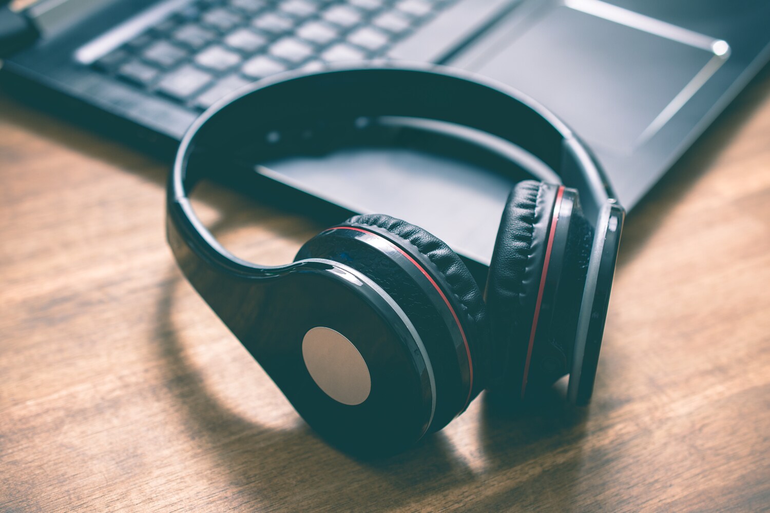 Ein Overhead Funkkopfhörer liegt vor einer Laptop-Tastatur.