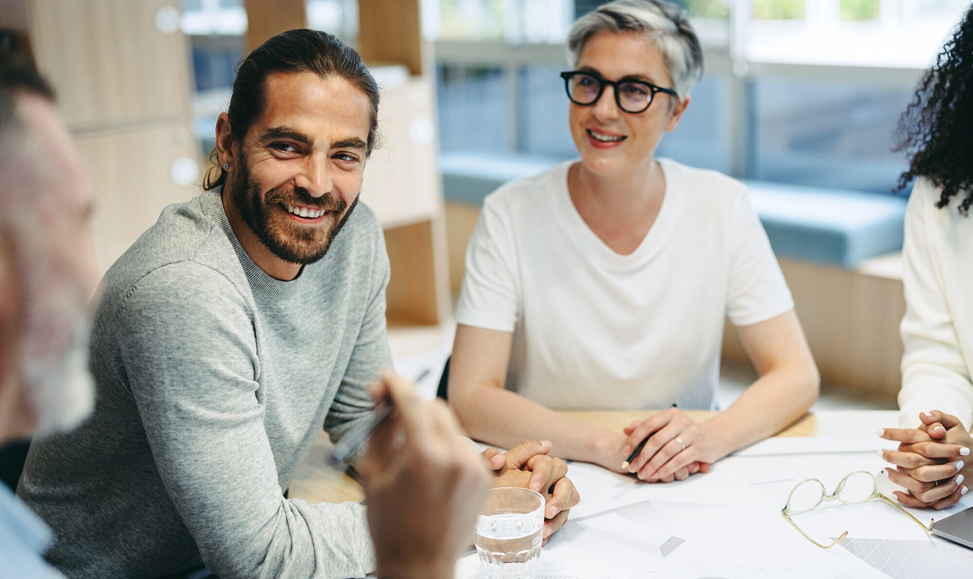 Leadership Match: finde deinen Führungsstil! Freundliche Kolleg:innen sitzen gemeinsam am Besprechungstisch.