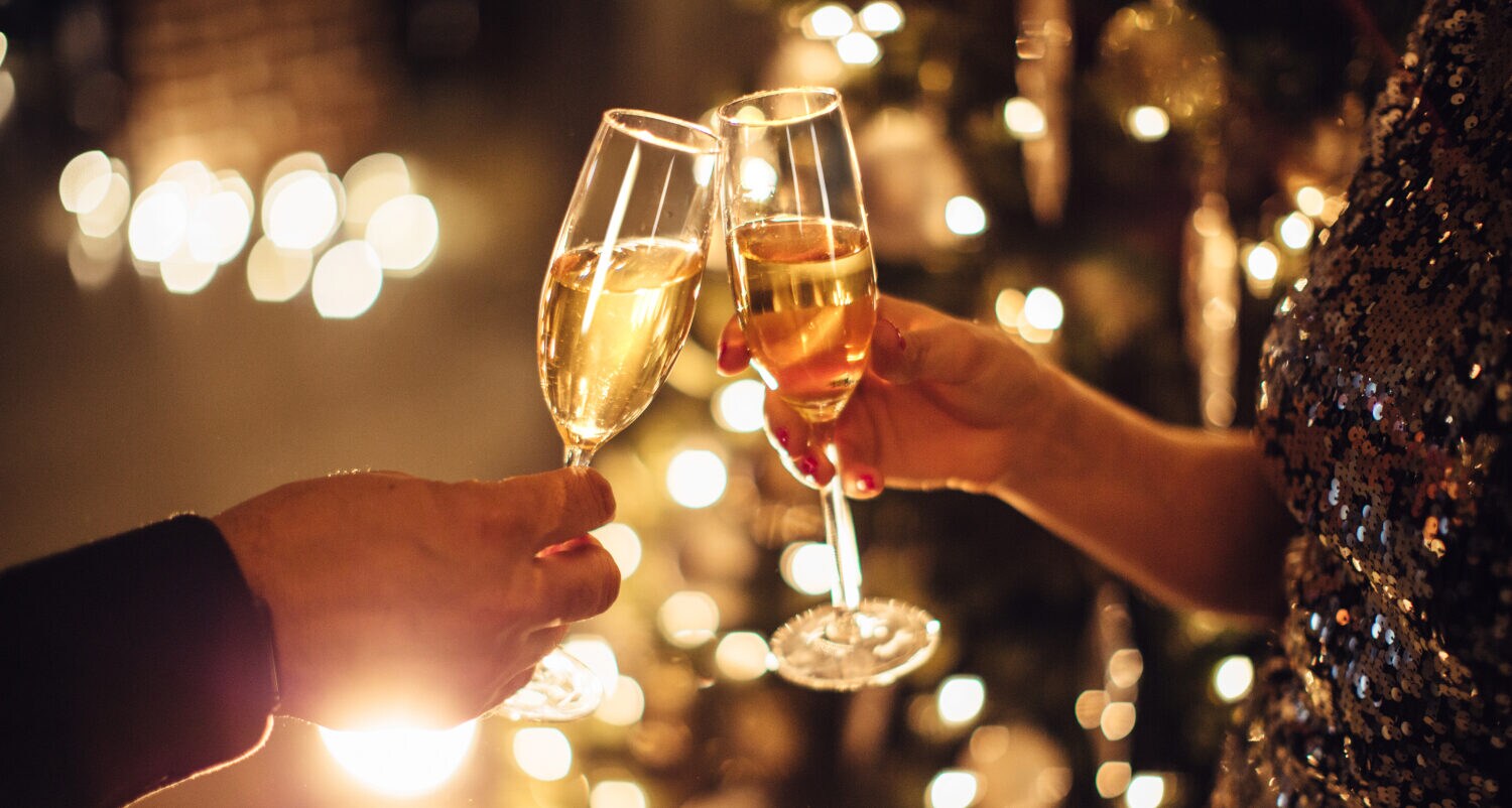 Zwei Personen stoßen mit Sektgläsern an