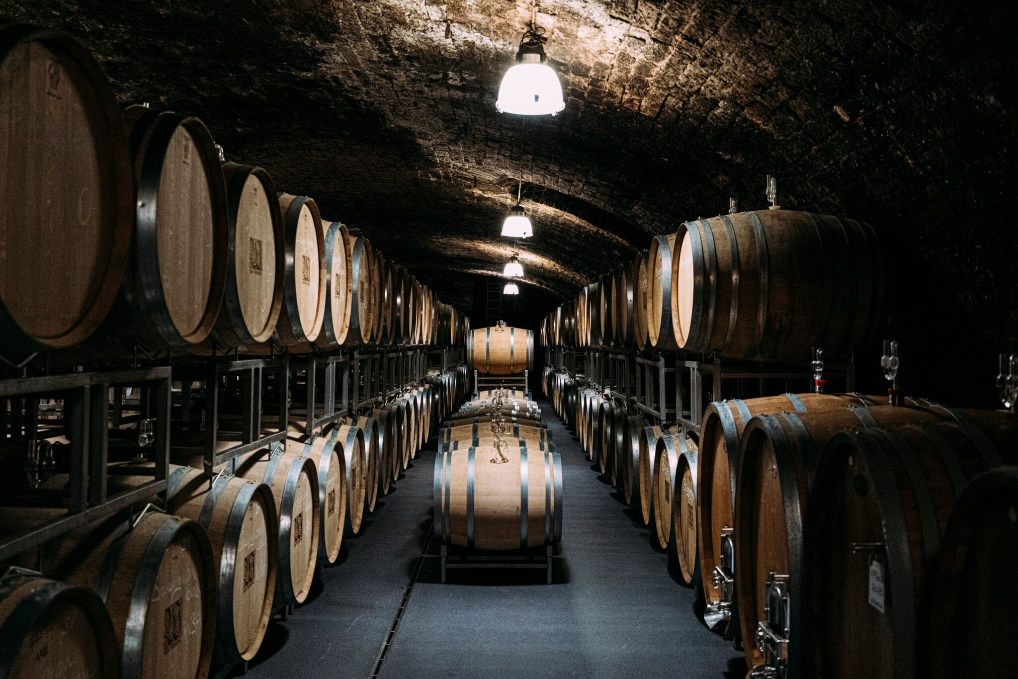 Ein dunkler mit Holzfässern gefüllter Weinkeller Ein dunkler mit Holzfässern gefüllter Weinkeller