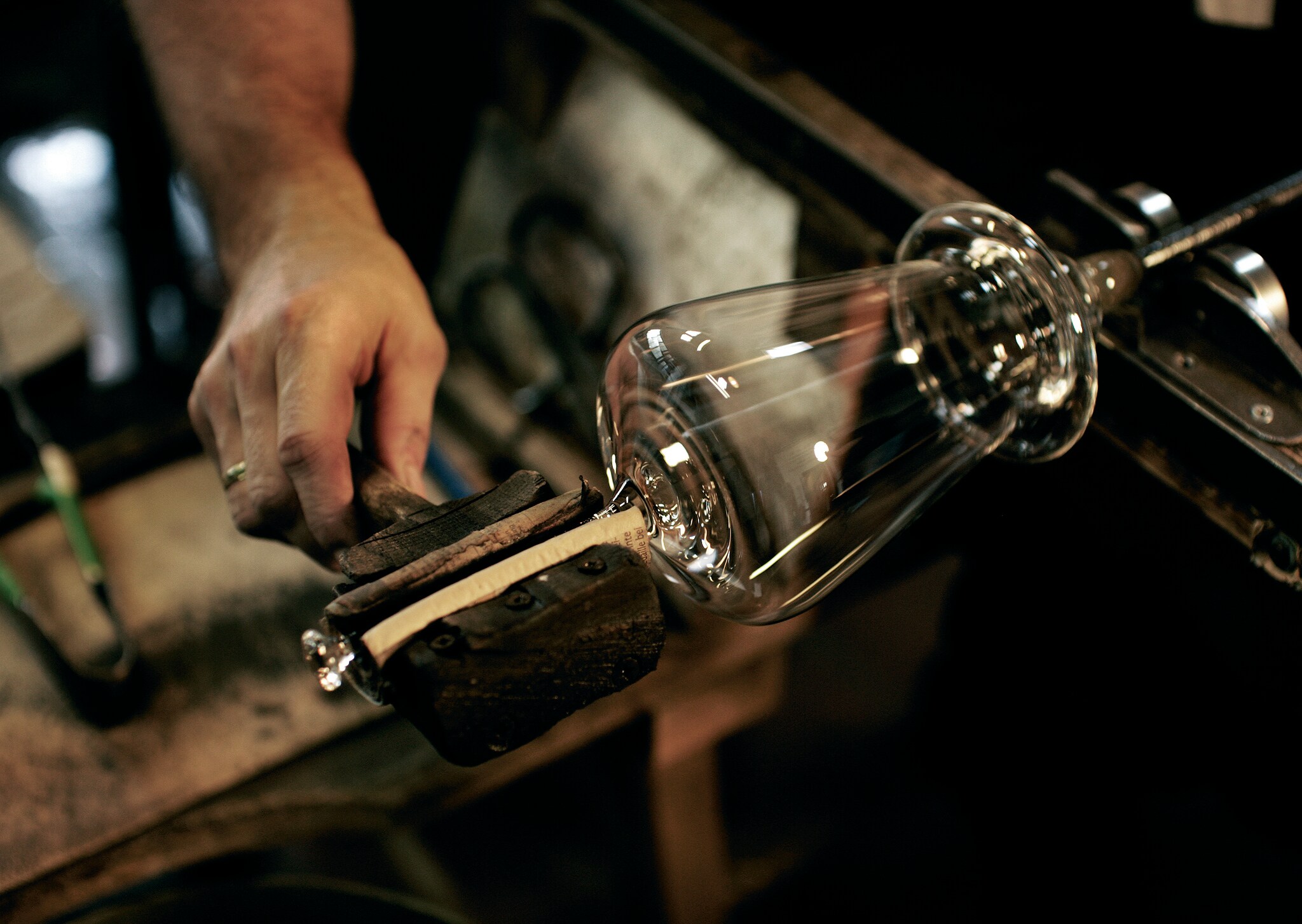 In einer Glasmanufaktur wird der Stil eines Weinglases geformt.