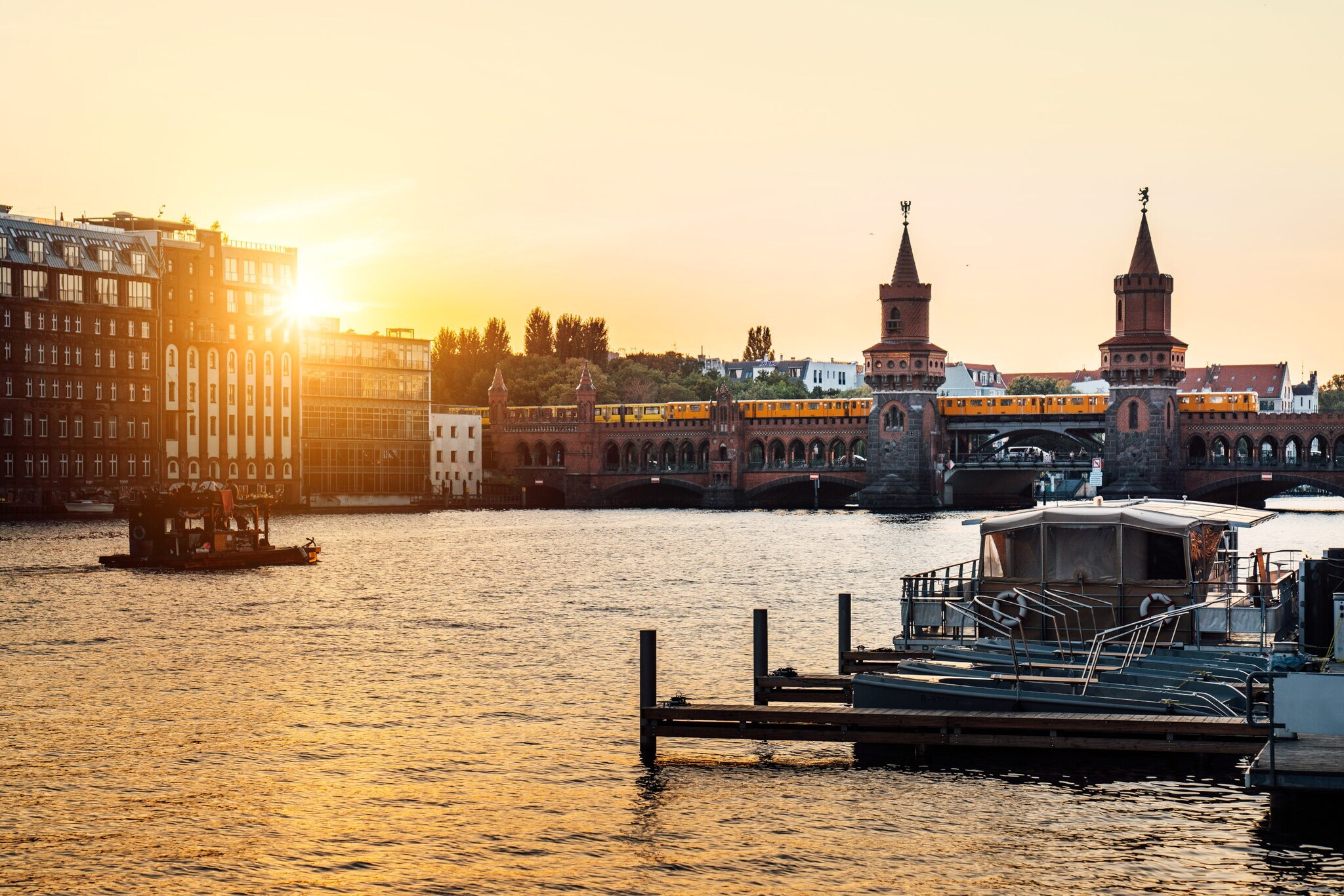 Sonnenuntergang über der Oberbaumbrücke in Berlin mit vorbeifahrender U-Bahn und Booten auf der Spree. Sonnenuntergang über der Oberbaumbrücke in Berlin mit vorbeifahrender U-Bahn und Booten auf der Spree.