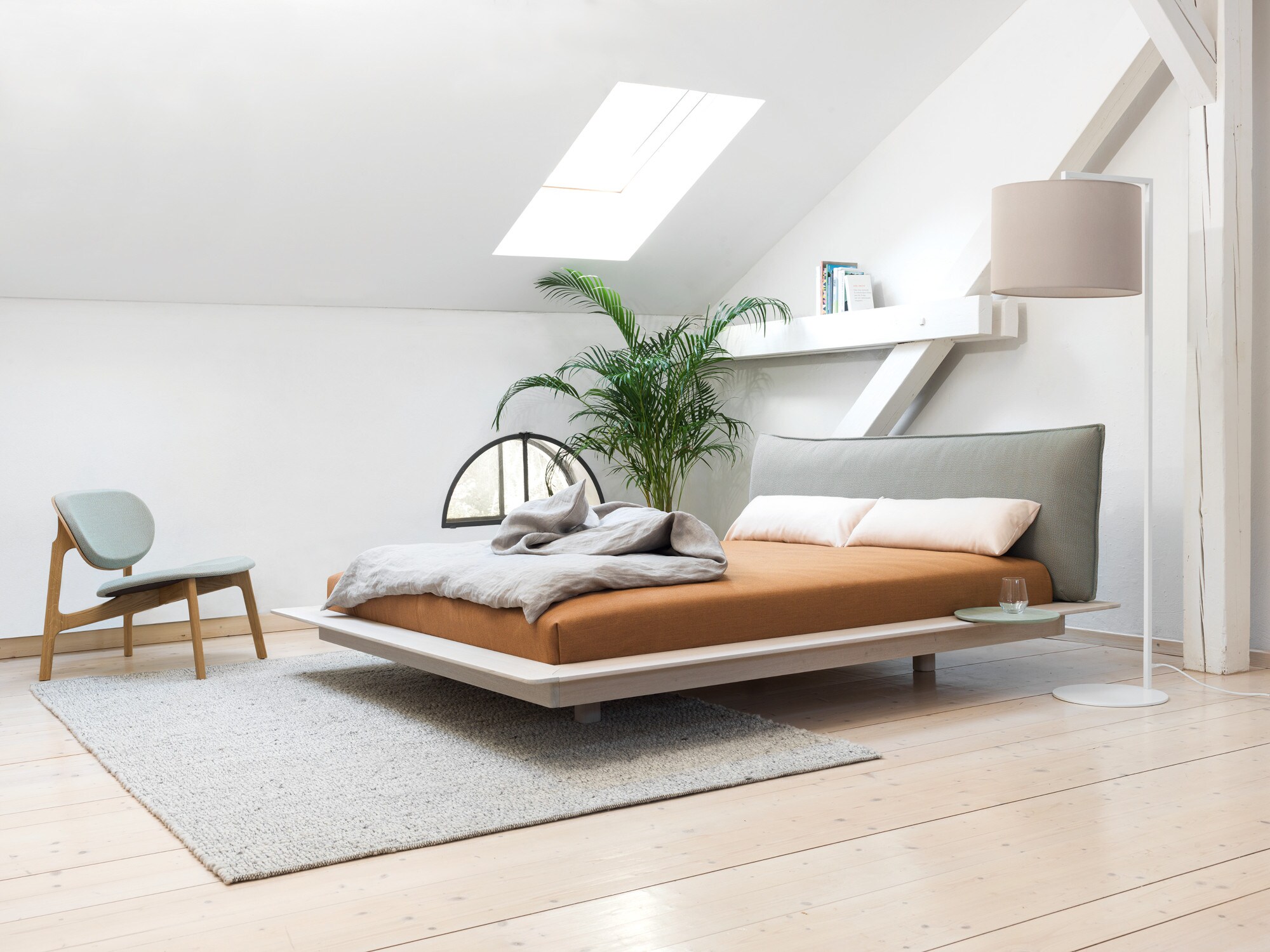 Helles, modernes Schlafzimmer mit einem großen Futonbett im minimalistischen Design Helles, modernes Schlafzimmer mit einem großen Futonbett im minimalistischen Design