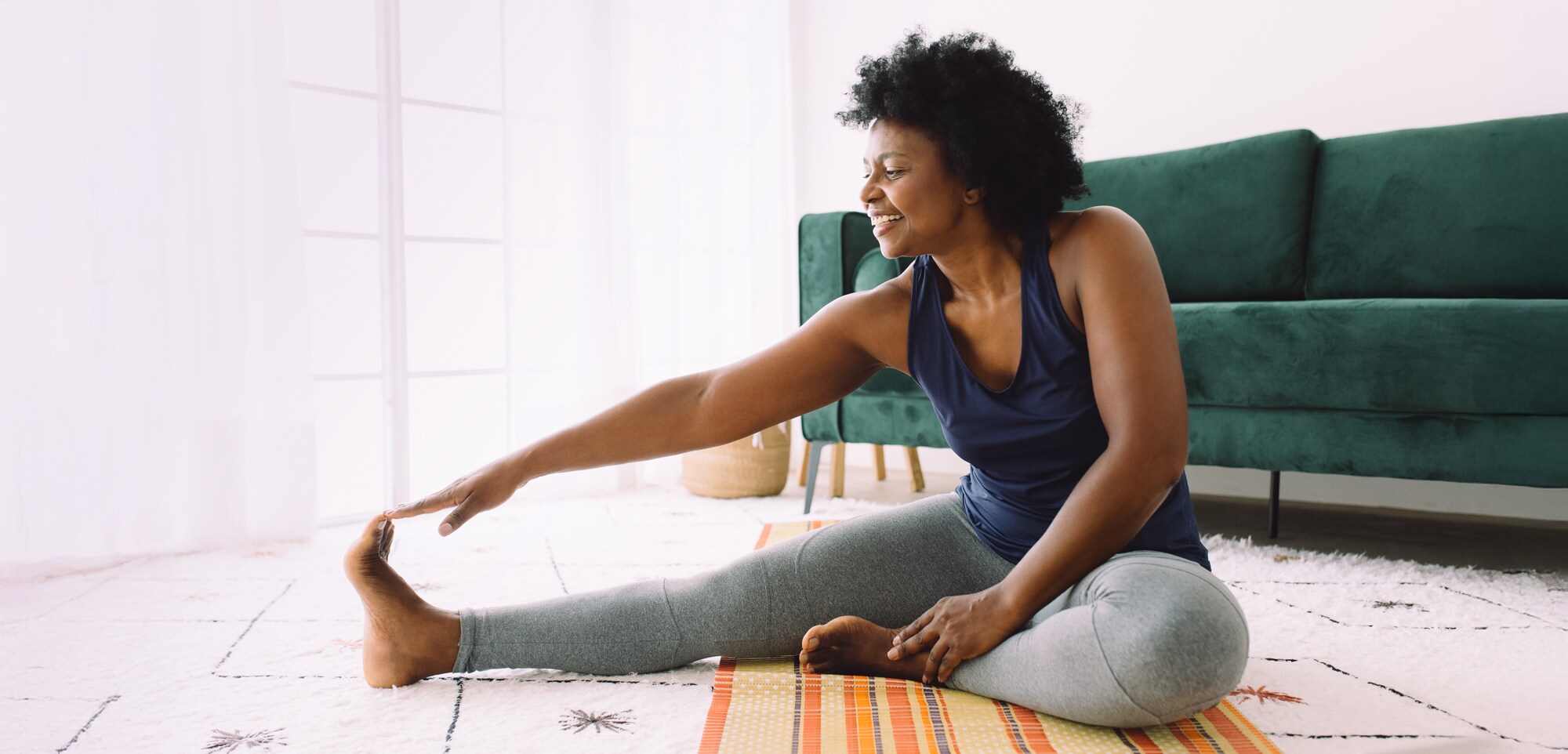 Auch für Eulen: Mit Morgenroutine produktiv in den Tag starten Eine Frau macht Yoga am frühen Morgen.