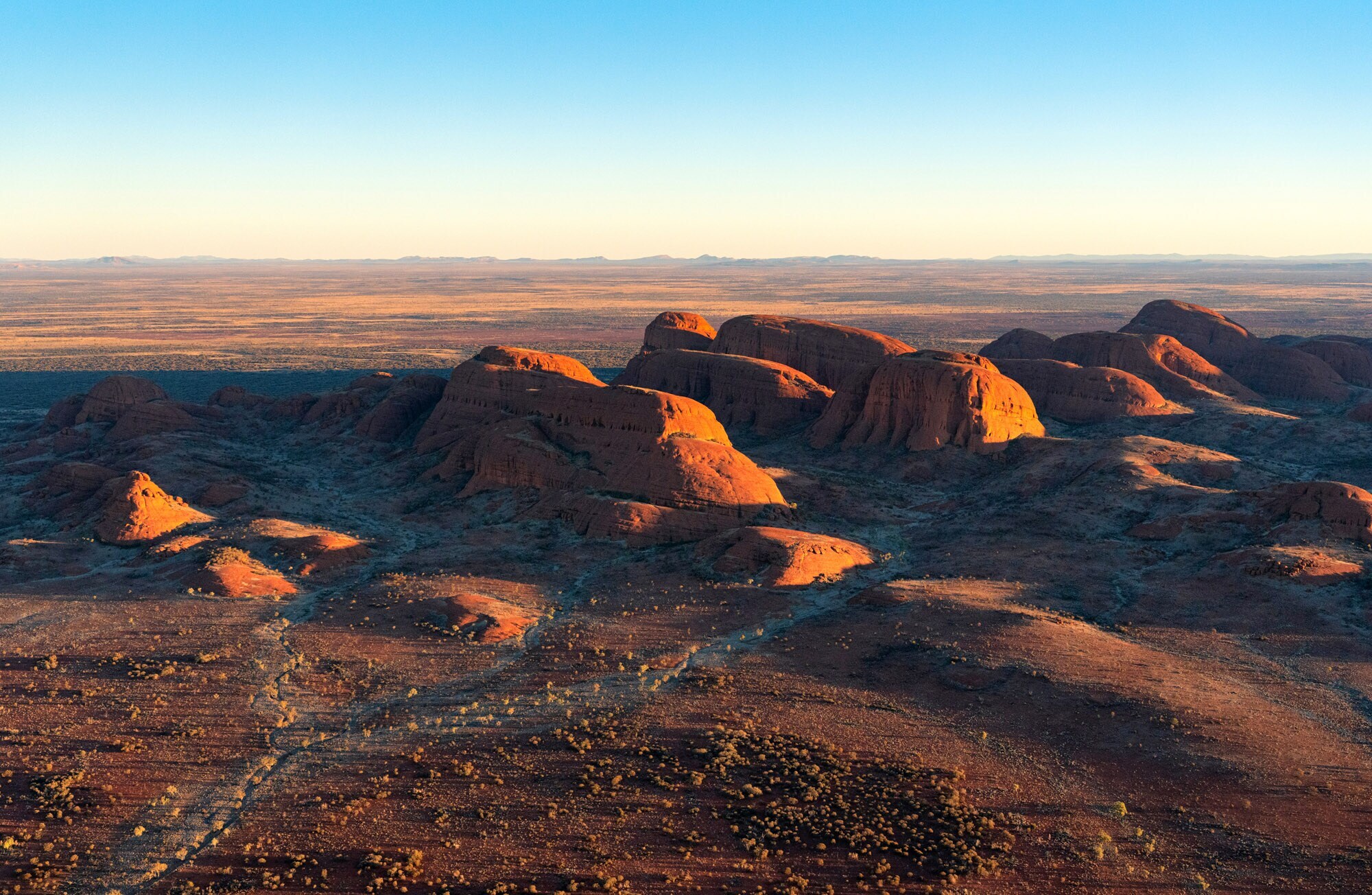 Luftaufnahme von gigantischen Sandsteinfelsen in einer Wüstenlandschaft in der Abendsonne