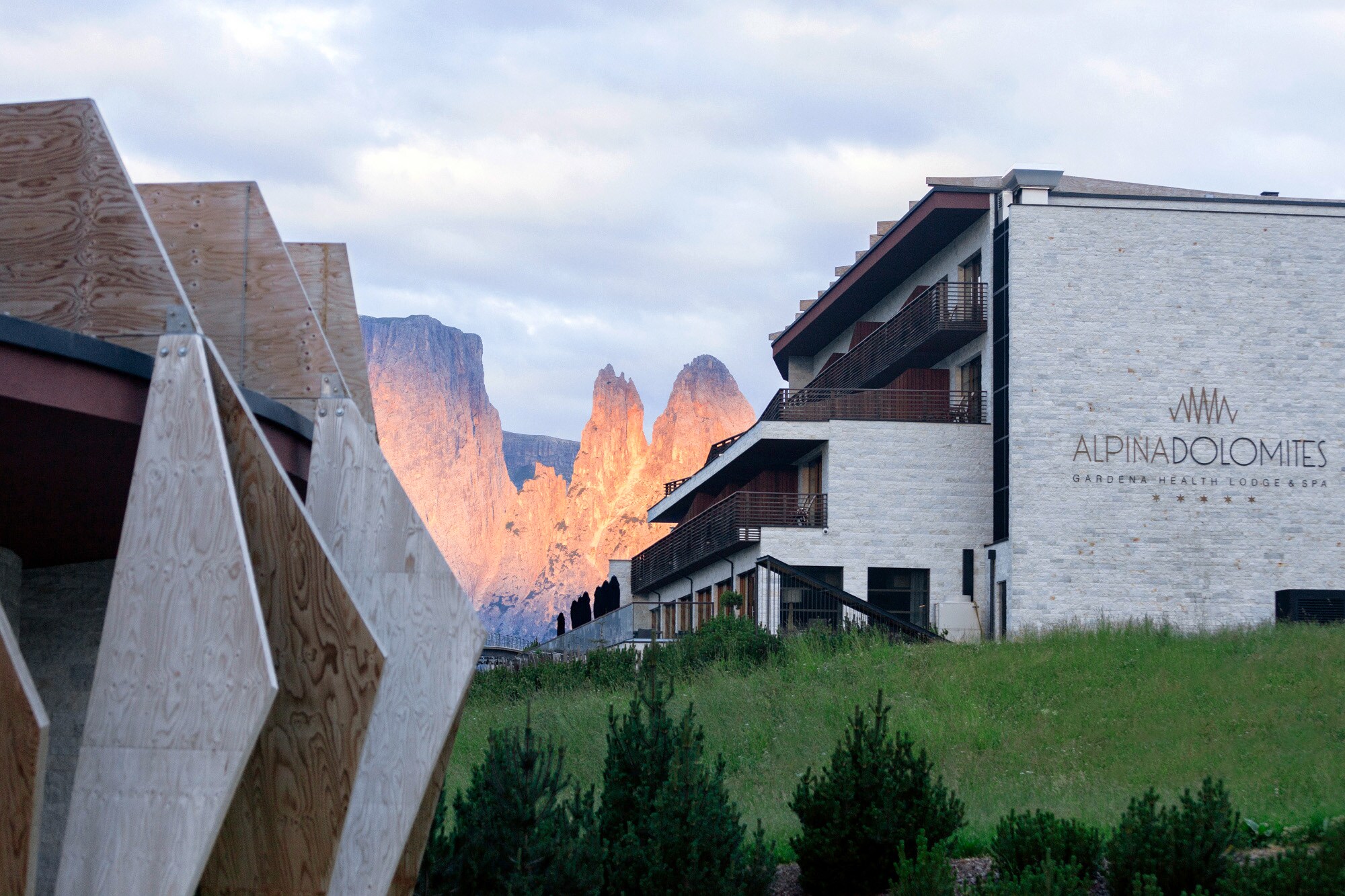 Hinter dem Hotel Alpina Dolomites werden die Gipfel der Dolomiten vom Licht des Sonnenuntergangs rötlich angestrahlt