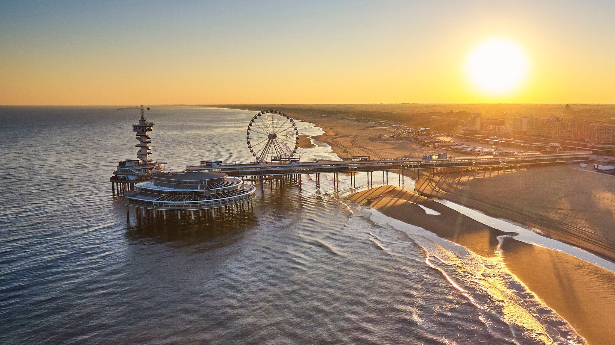 Luftaufnahme des Strandes und Riesenrads am De Pier in Scheveningen bei Den Haag bei Sonnenuntergang. Luftaufnahme des Strandes und Riesenrads am De Pier in Scheveningen bei Den Haag bei Sonnenuntergang.