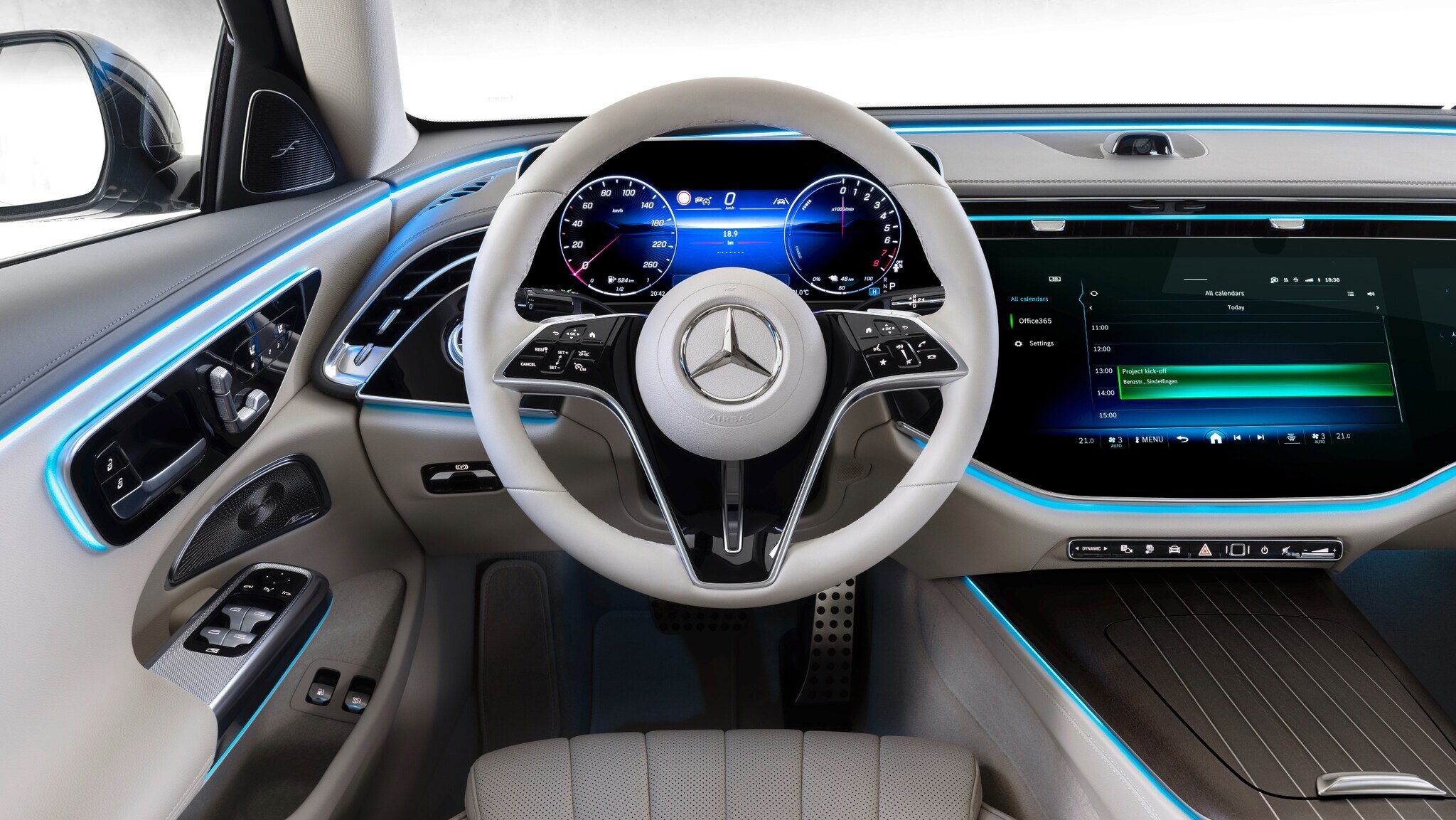 Das Cockpit einen Mercedes mit hellem Lenkrad, heller Verkleidung und großem Display
