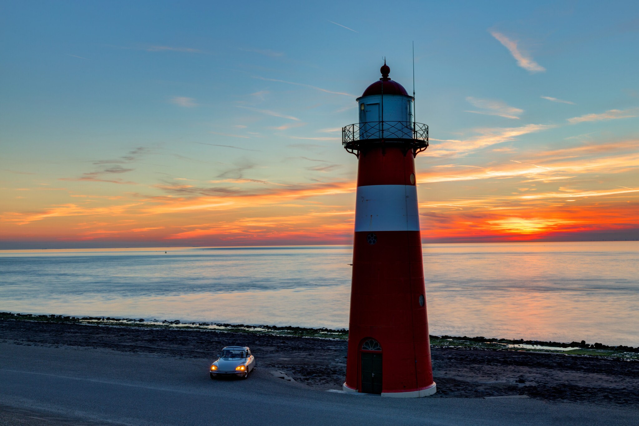 Ein Auto steht am Leuchtturm IJzeren torentje. Ein Auto steht am Leuchtturm IJzeren torentje.