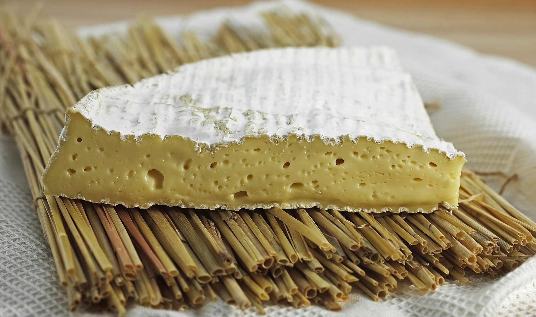 Ein Stück Brie-Käse auf einer Bambusmatte angerichtet