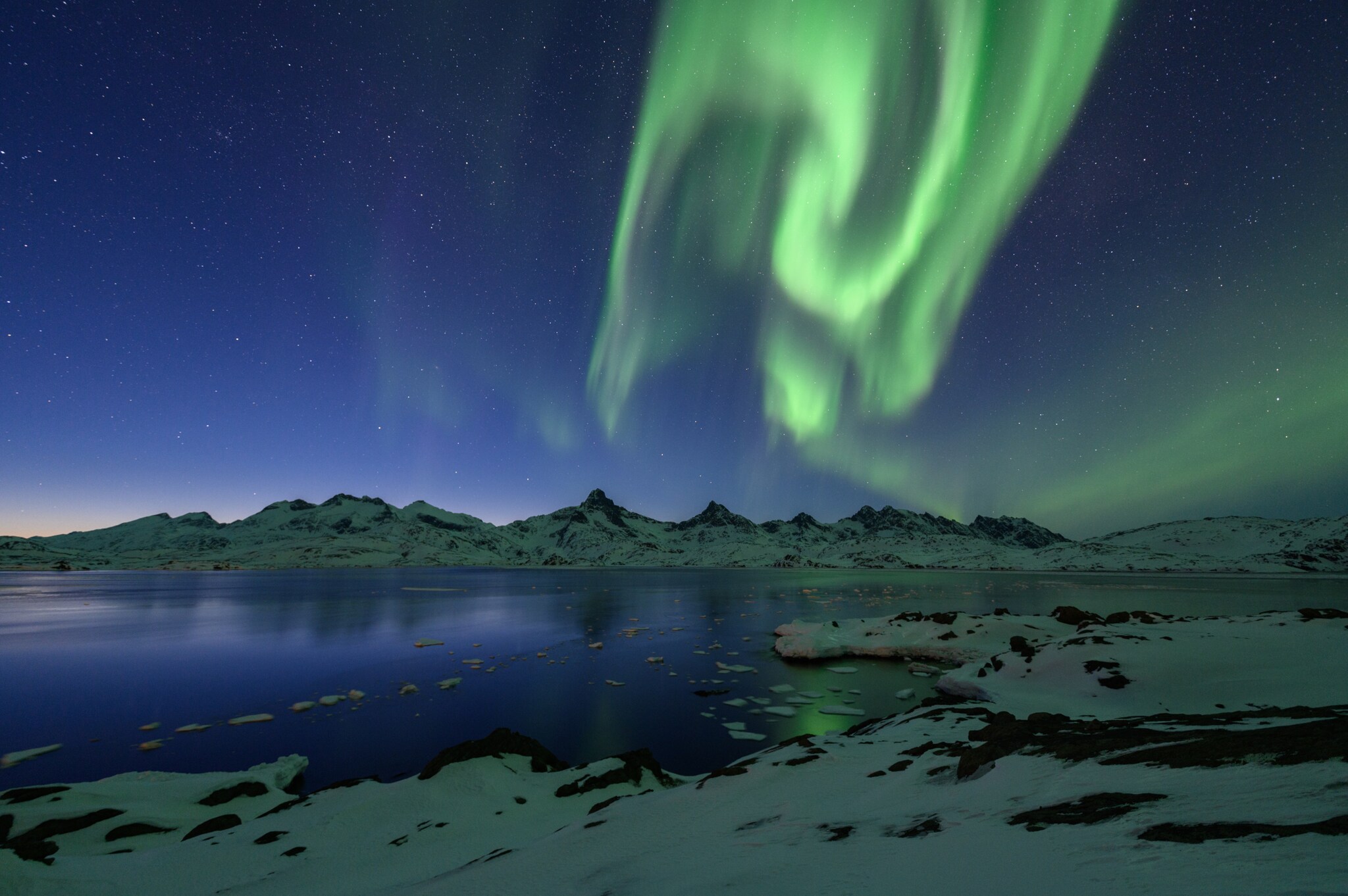 Grün leuchtende Aurora Borealis über dem Tasiilaq-Fjord in Ostgrönland.