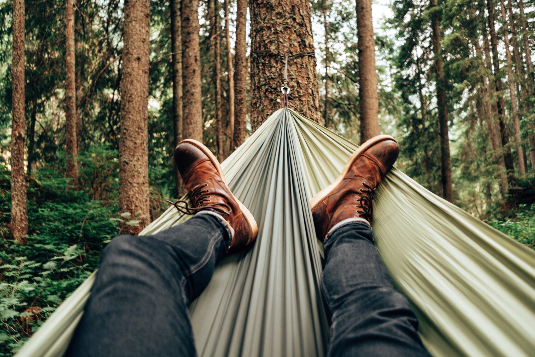 Mann entspannt in einer Hängematte im Wald