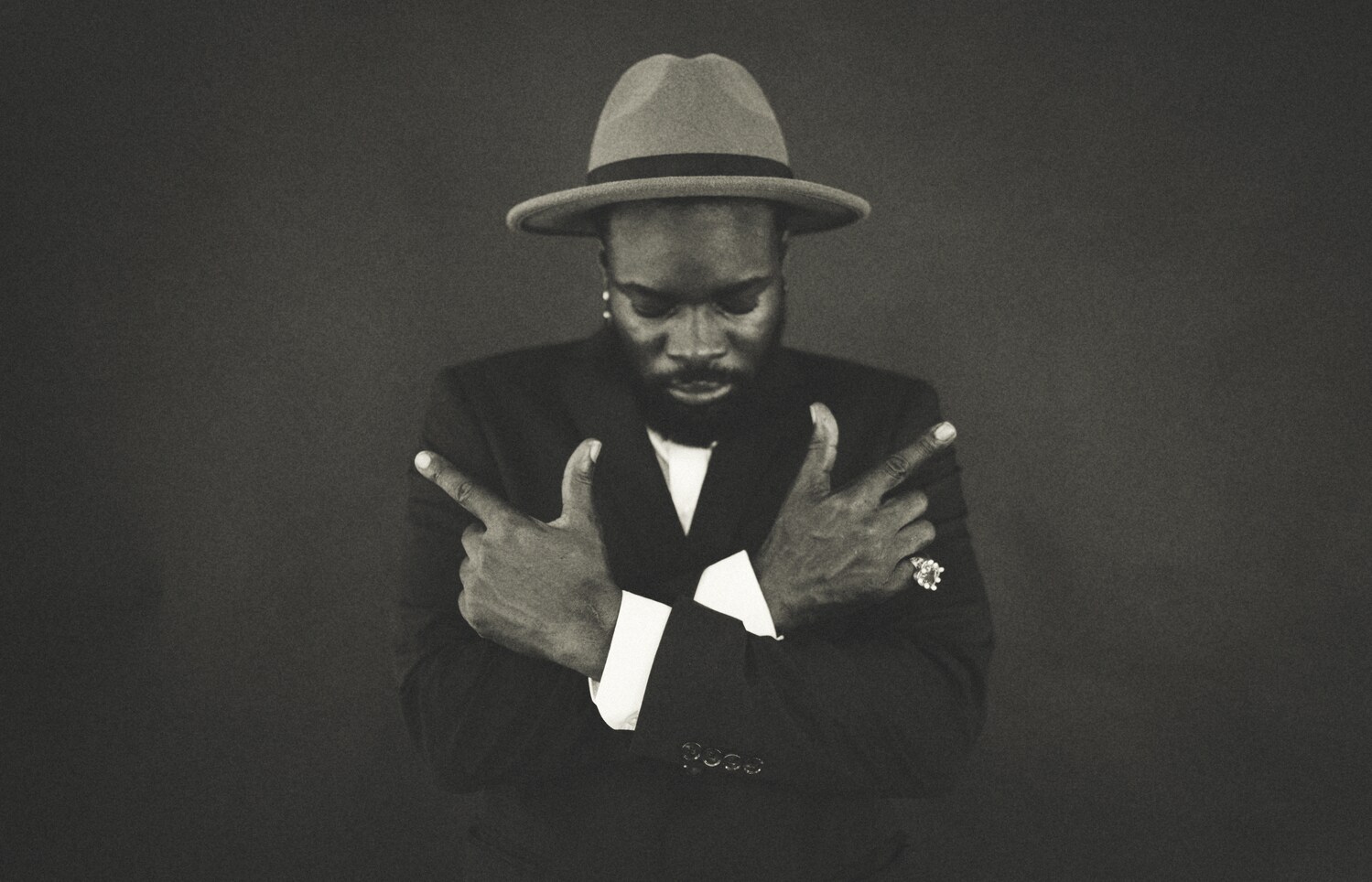 Eine Schwarz-Weiß-Aufnahme eines Mannes mit Hut, der hinab blickt