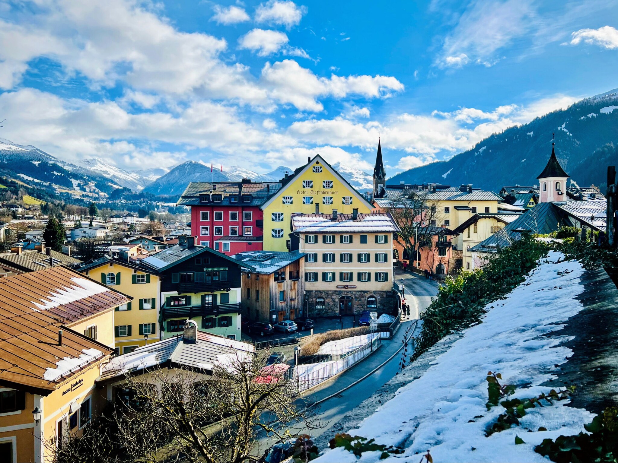 Altstadt von Kitzbühel, eingebettet in verschneite Berglandschaft.