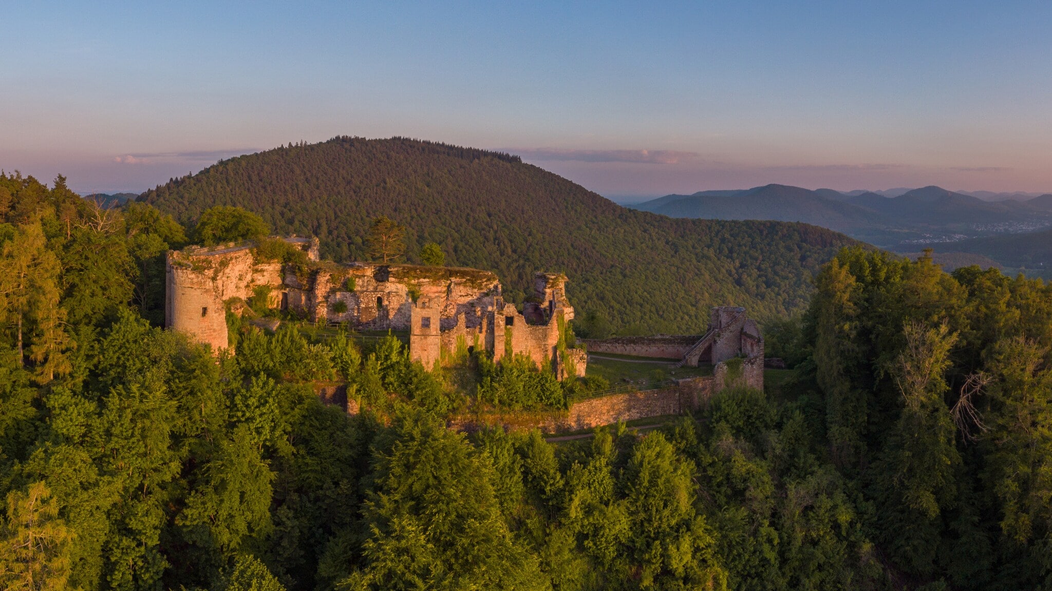 Panoramablick auf den Pfälzerwald mit Burgruine im Sonnenaufgang Panoramablick auf den Pfälzerwald mit Burgruine im Sonnenaufgang