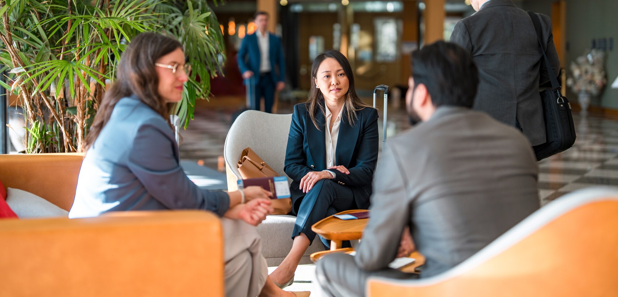 Drei Geschäftsleute sitzen in der Flughafenlounge.