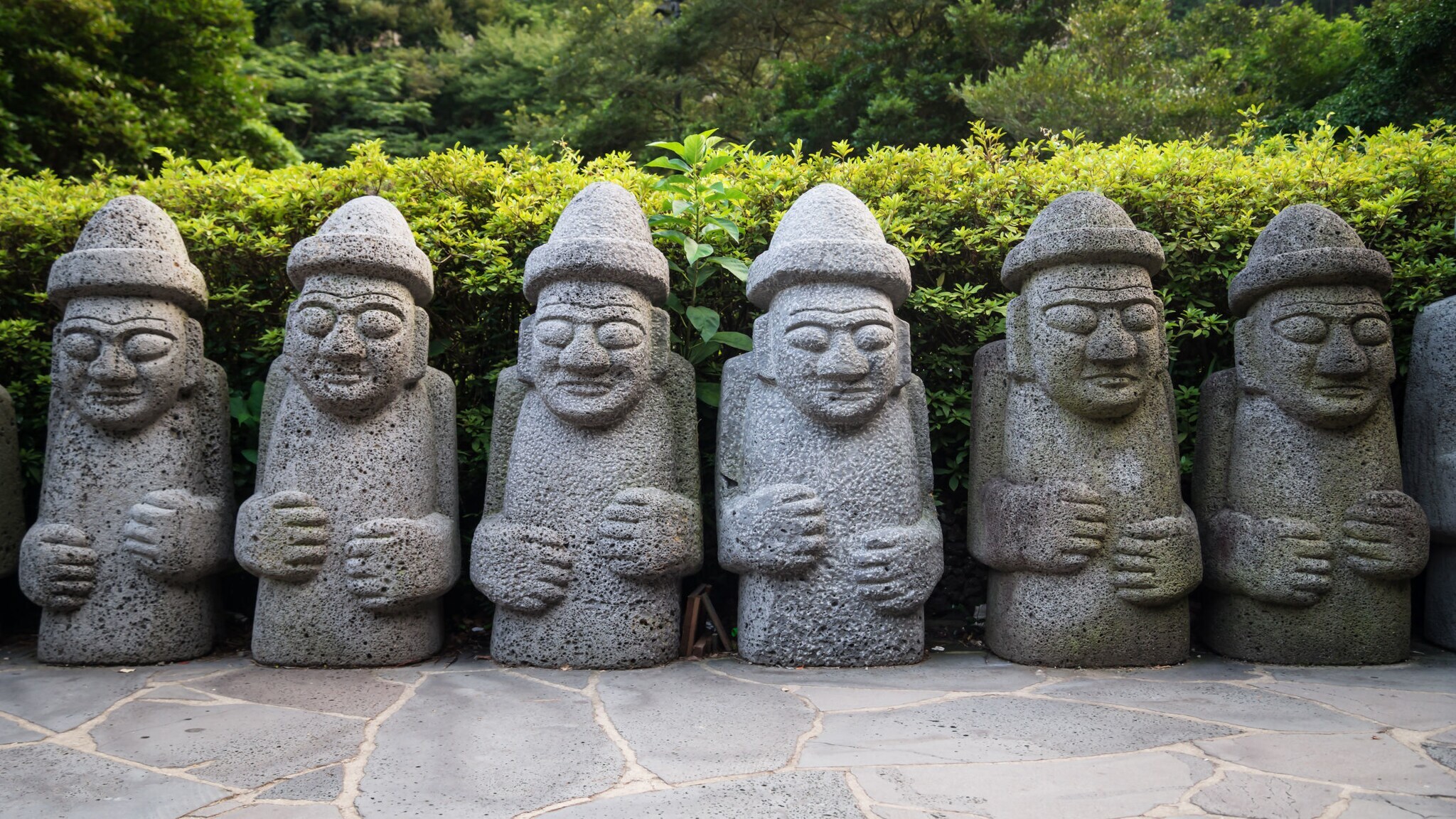 Eine Reihe von mehreren Steinfiguren nach männlichem Abbild mit Hut. Eine Reihe von mehreren Steinfiguren nach männlichem Abbild mit Hut.