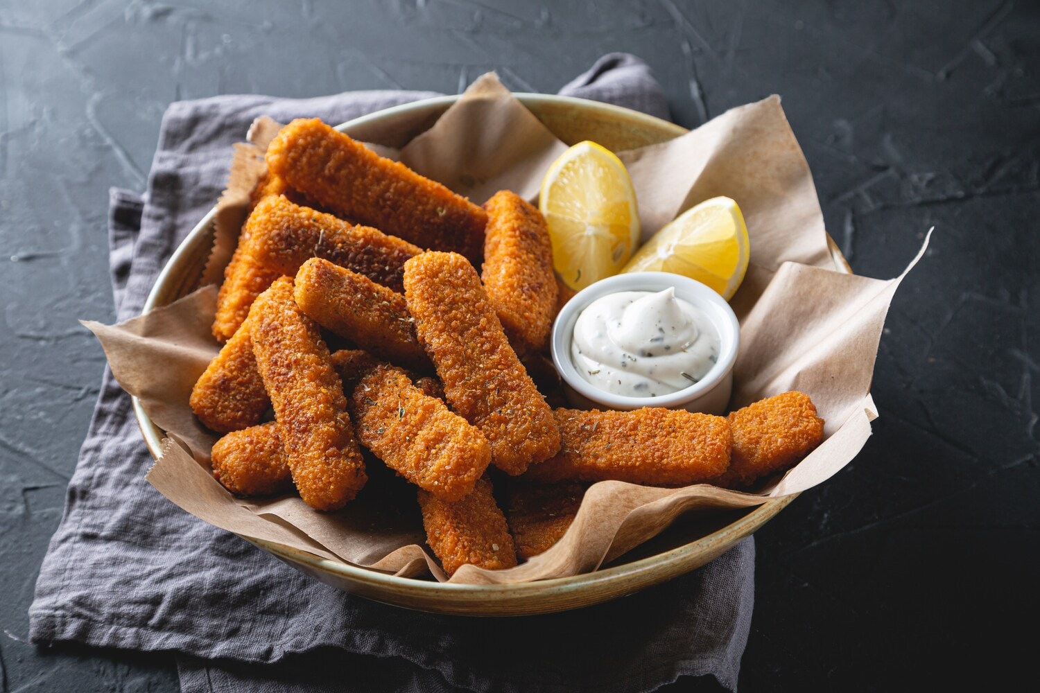 Ein Teller mit Fischstäbchen, zwei Zitronenspalten und einem Töpfchen Remoulade Ein Teller mit Fischstäbchen, zwei Zitronenspalten und einem Töpfchen Remoulade