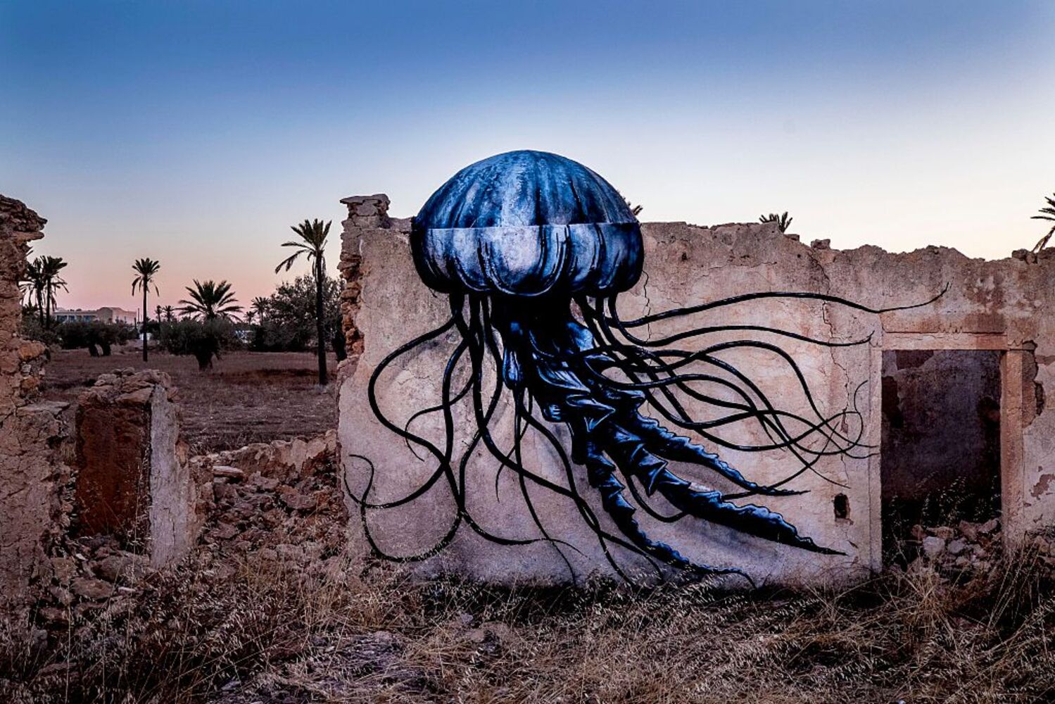 Eine blau-schwarze Qualle des Künstlers ROA auf einer Ruinenmauer in Tunesien.
