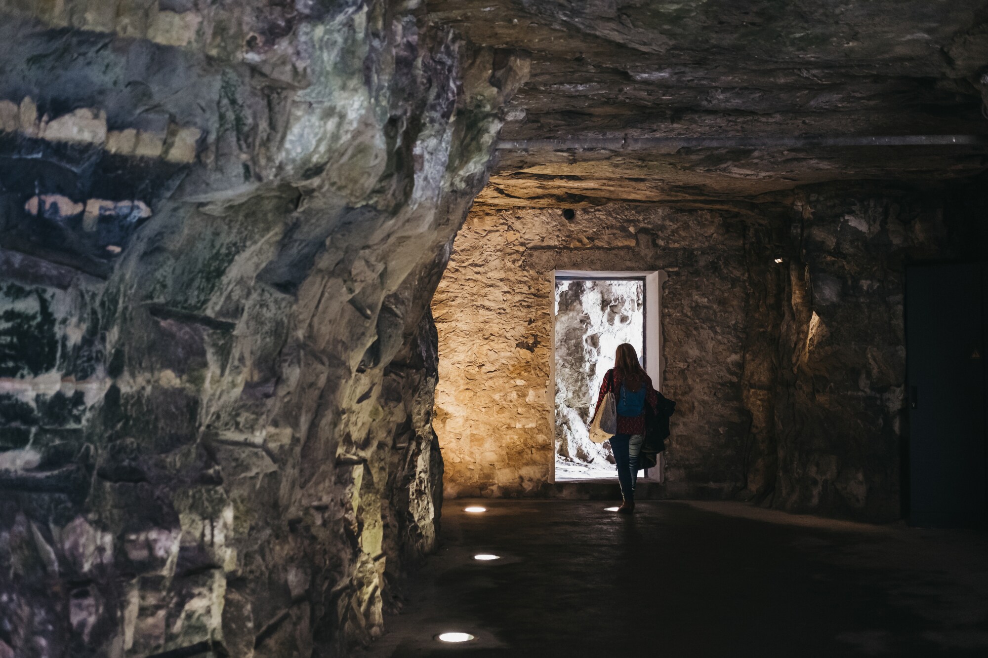 Eine Person läuft durch einen unterirdischen Gang Eine Person läuft durch einen unterirdischen Gang