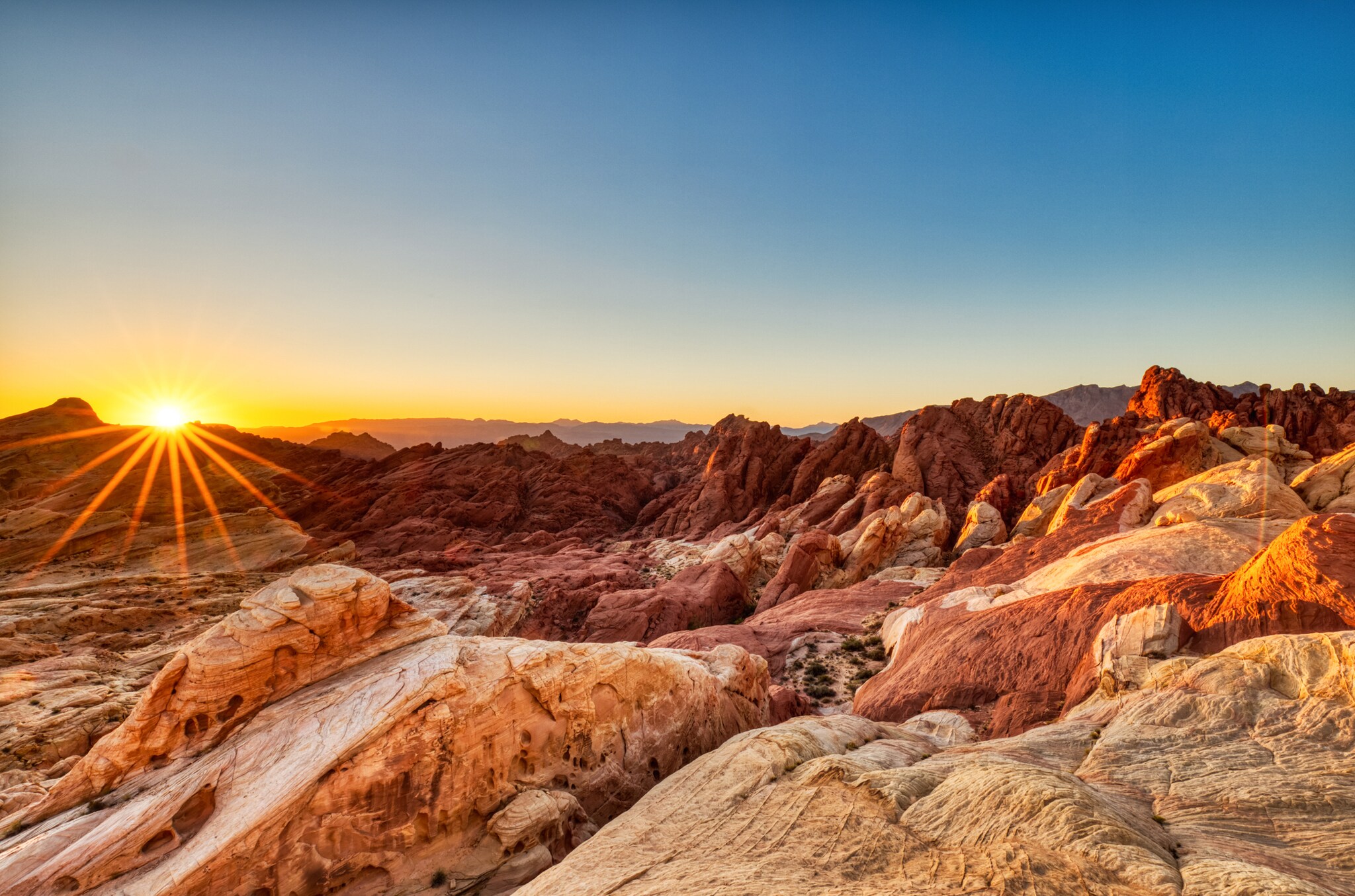 Eine bergige Wüstenlandschaft mit strahlender Sonne
