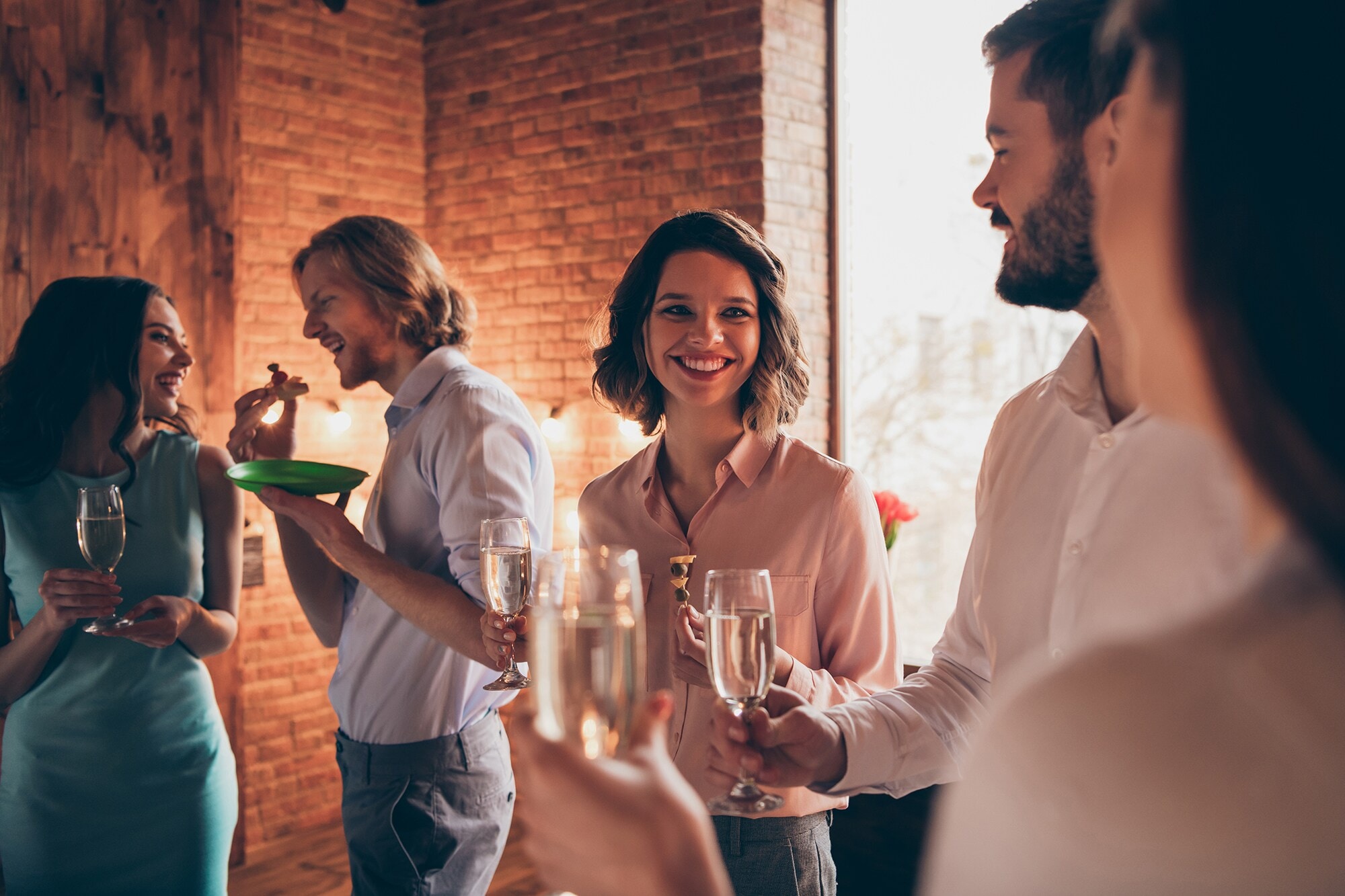 Let’s Party: Business-Dresscodes und Style-Tipps für festliche Zeiten Eine Gruppe entspannter Frauen und Männer während einer Firmenfeier