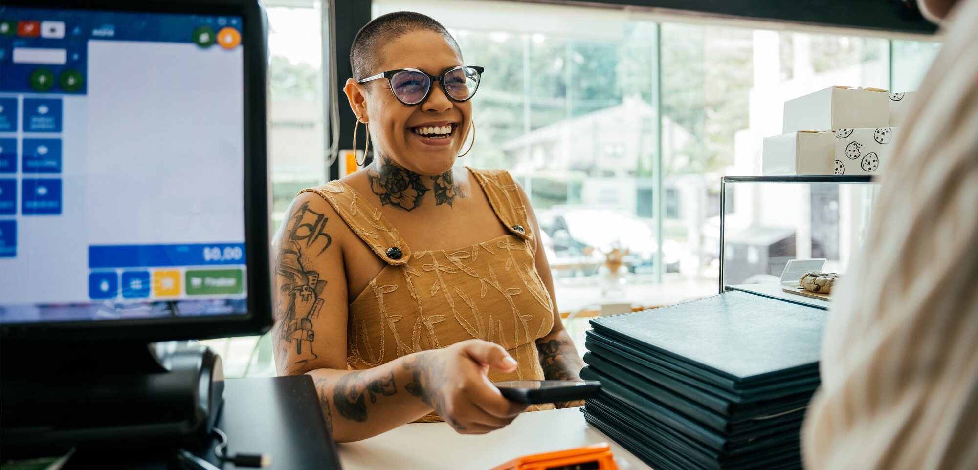 Maximale Flexibilität: Vom Pop-up-Store bis zum Straßenfest Foto einer jungen Frau, die an der Kasse eines Cafés eine Zahlung per Smartphone tätigt.