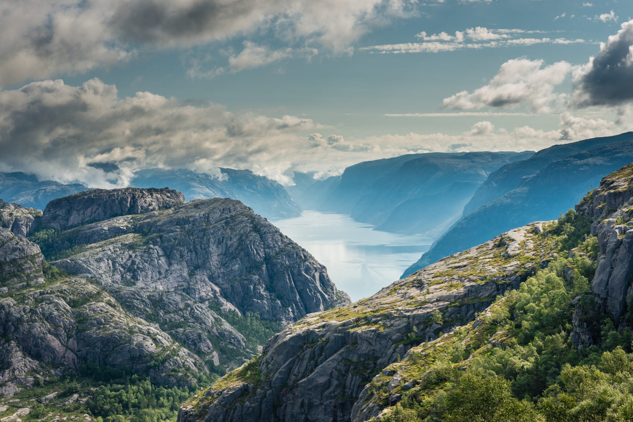 Blick auf begrünte Felsen, die einen Fjord umgeben. Blick auf begrünte Felsen, die einen Fjord umgeben.