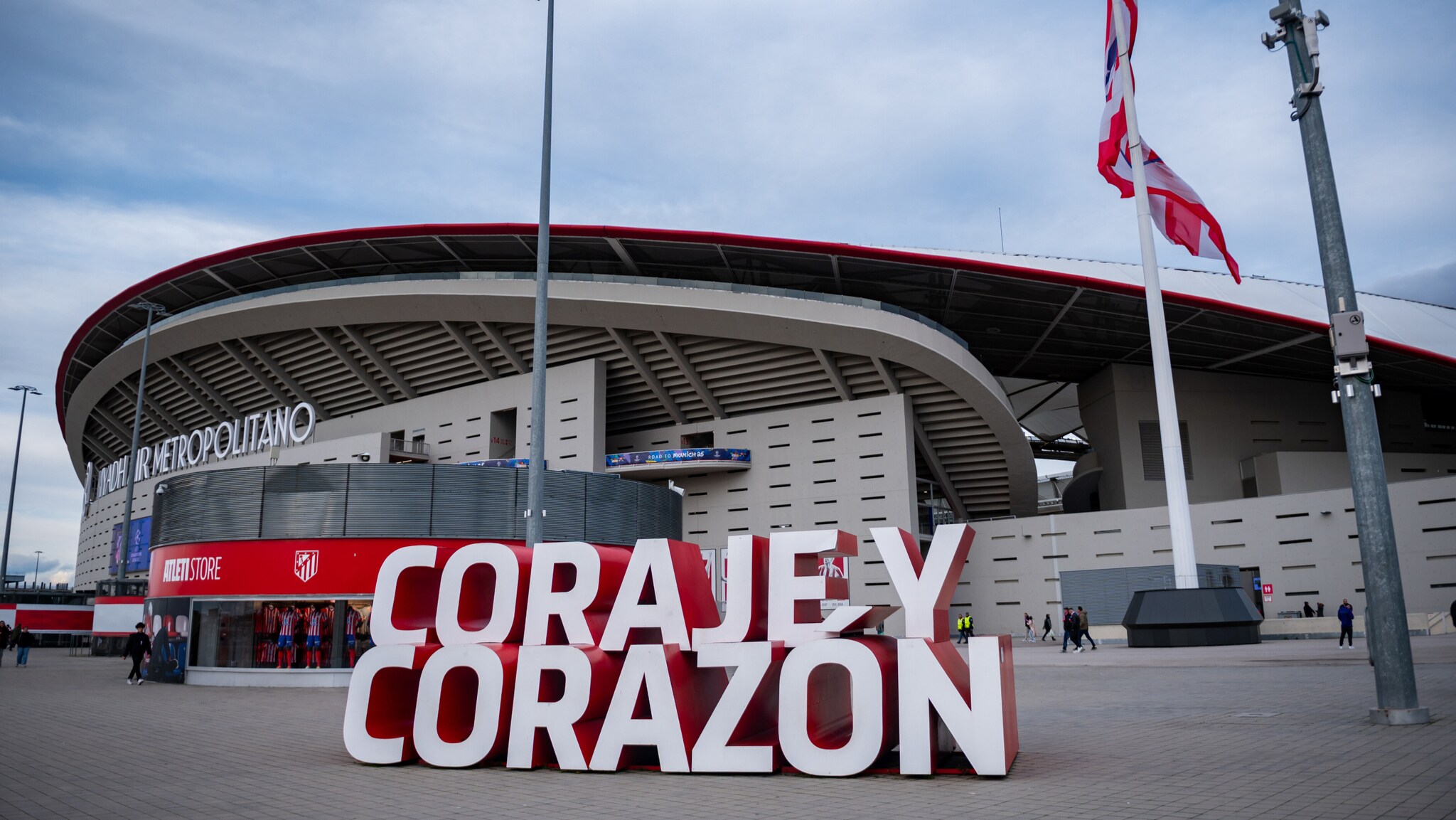 Das Estadio Metropolitano mit dem Schriftzug Das Estadio Metropolitano mit dem Schriftzug 'CORAJÉ Y CORAZÓN' im Vordergrund. Im Hintergrund sind Flaggen und die Stadionarchitektur sichtbar.