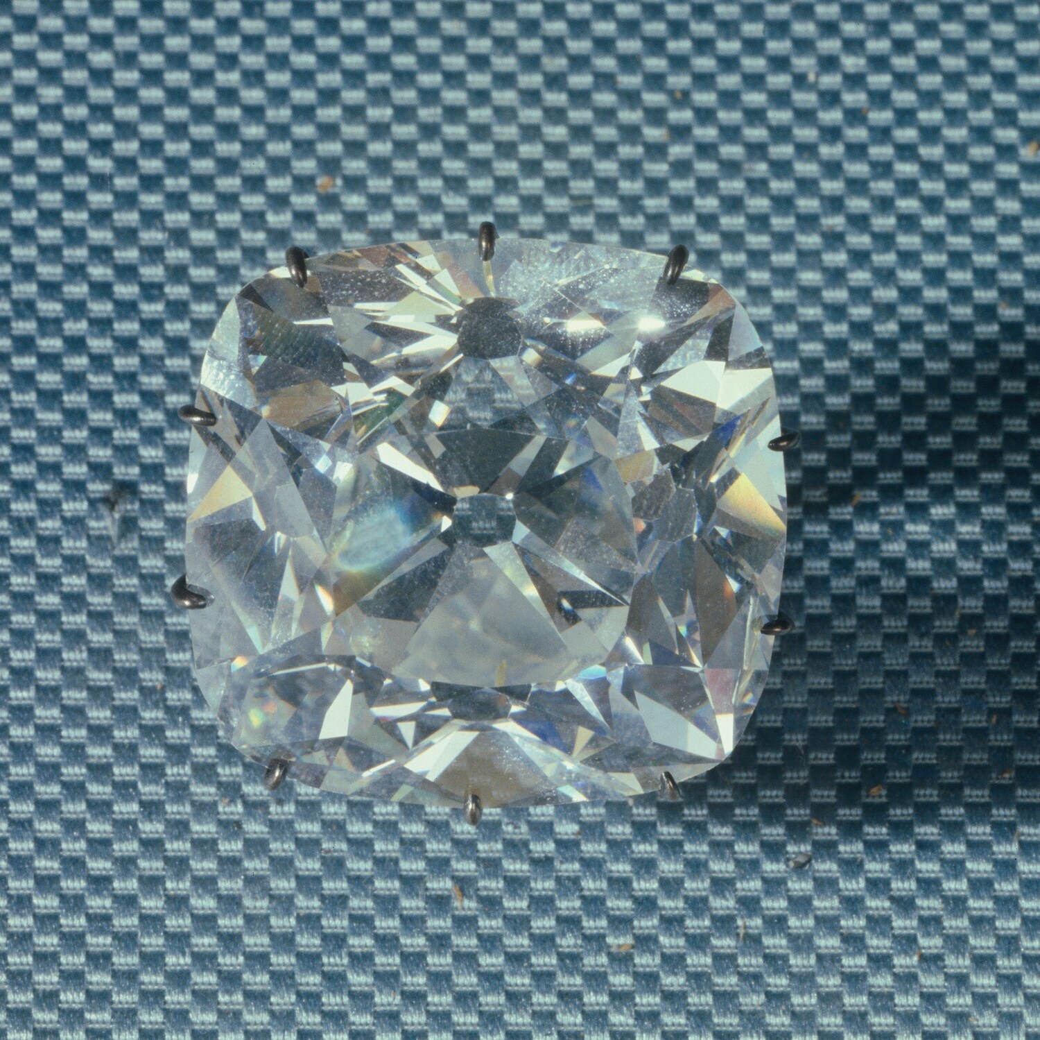 Ein eingefasster farbloser Diamant auf grauem Untergrund