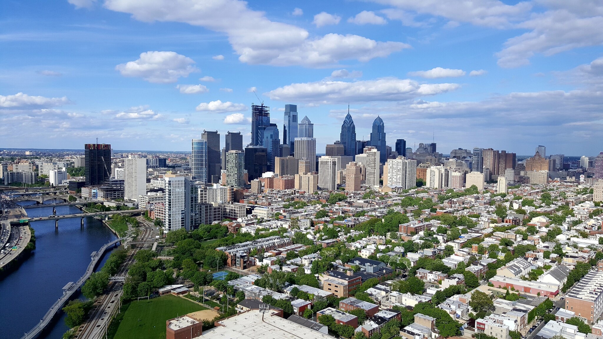 Skyline von Philadelphia mit niedrigen Häusern in begrüntem Wohnviertel vor Hochhäusern im Hintergrund. Skyline von Philadelphia mit niedrigen Häusern in begrüntem Wohnviertel vor Hochhäusern im Hintergrund.