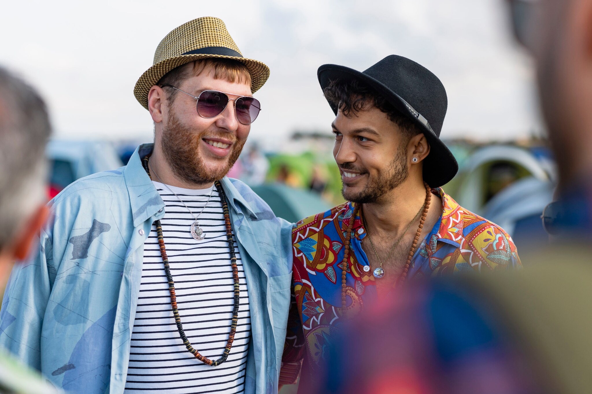 Zwei Männer mit Hüten und in bunter Kleidung auf einem Festival. Zwei Männer mit Hüten und in bunter Kleidung auf einem Festival.