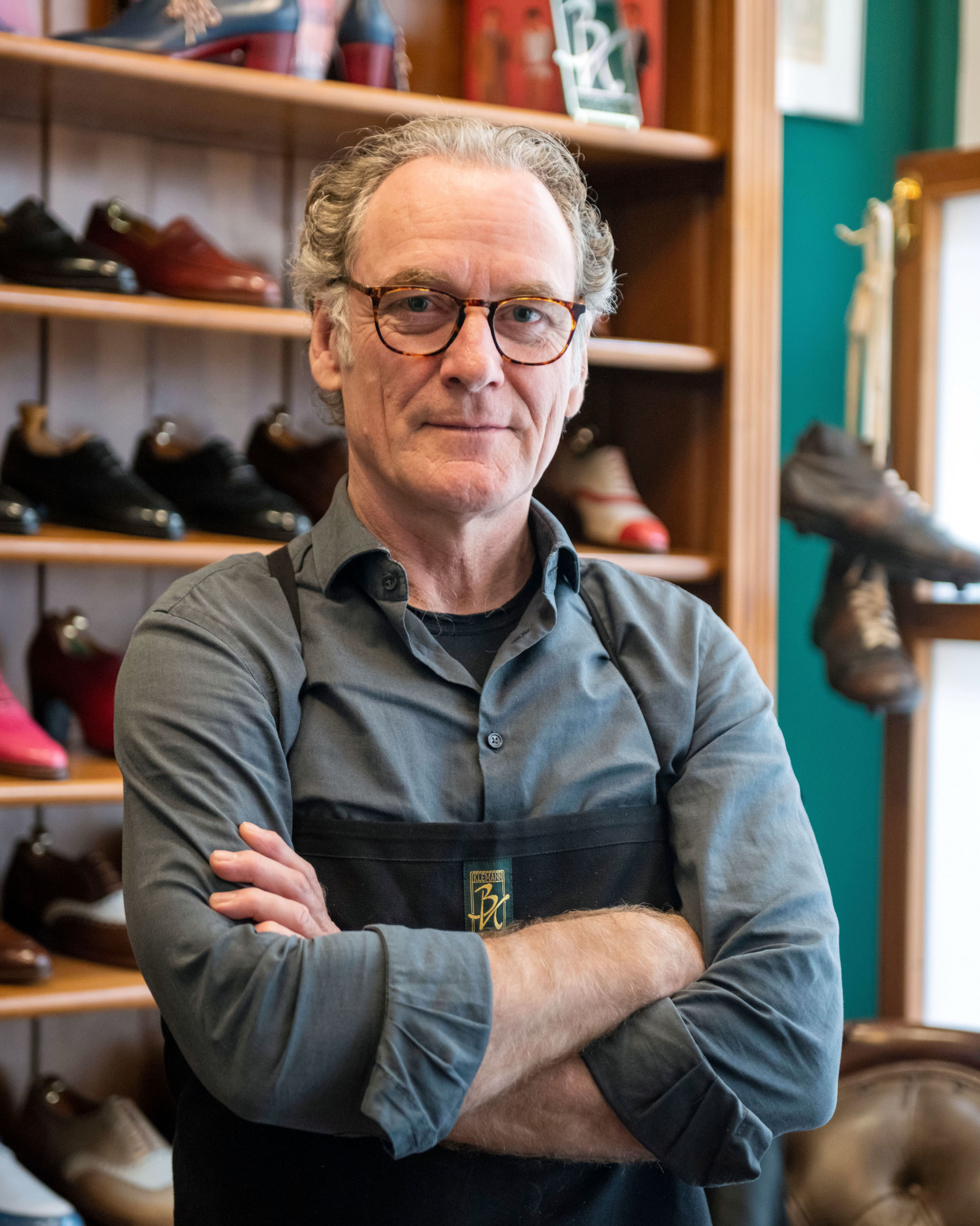 Schuhmachermeister Benjamin Klemann vor einem Schuhregal Schuhmachermeister Benjamin Klemann vor einem Schuhregal
