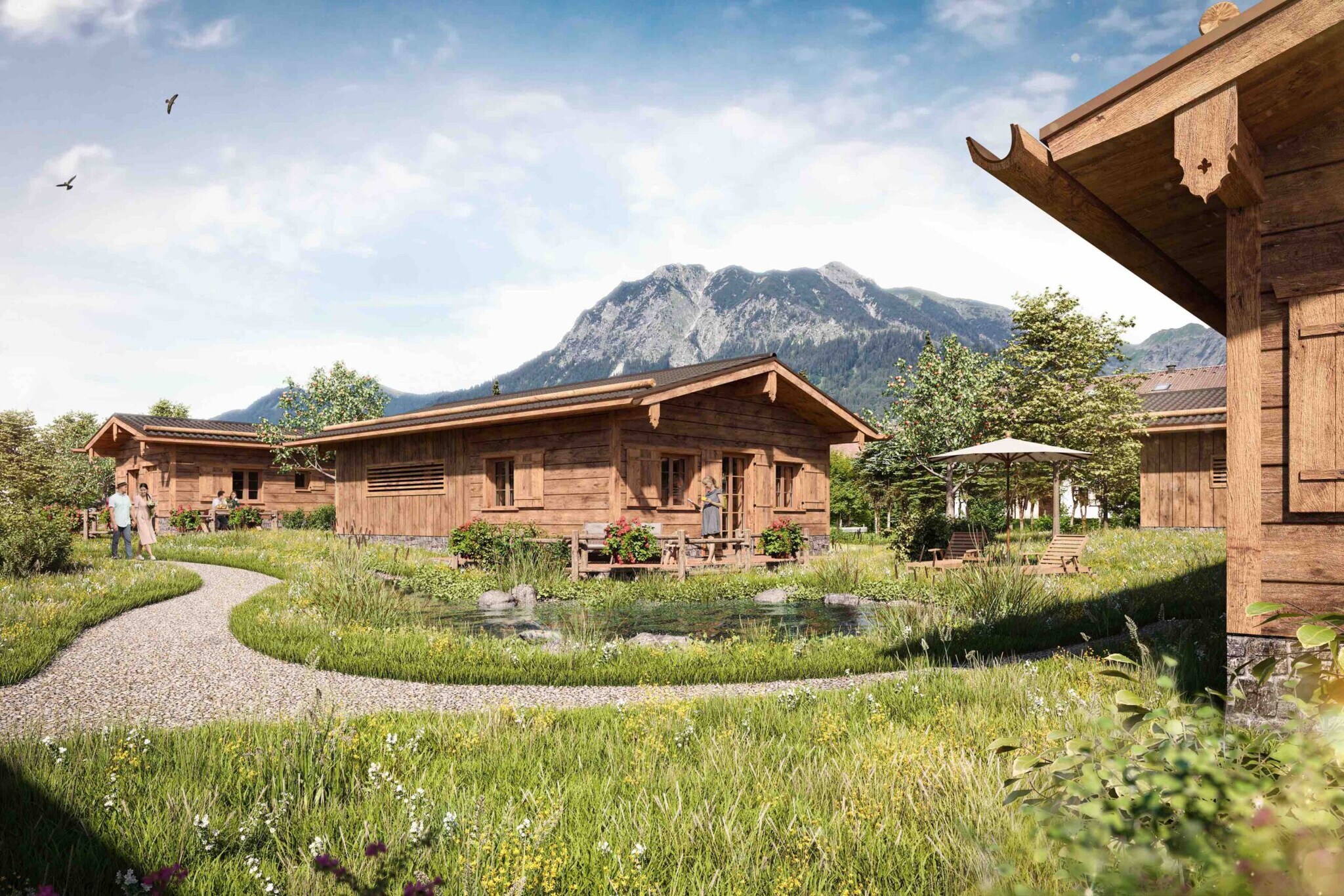 Ein traditionelles Holzhaus im Allgäu mit grüner Wiese und Bachlauf