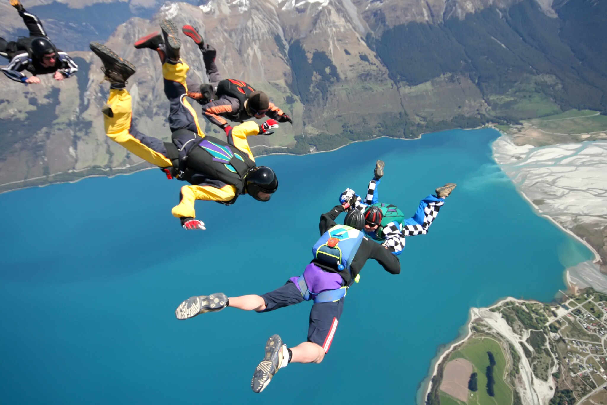 Mehrere Menschen beim Fallschirmspringen oberhalb eines Sees. Mehrere Menschen beim Fallschirmspringen oberhalb eines Sees.